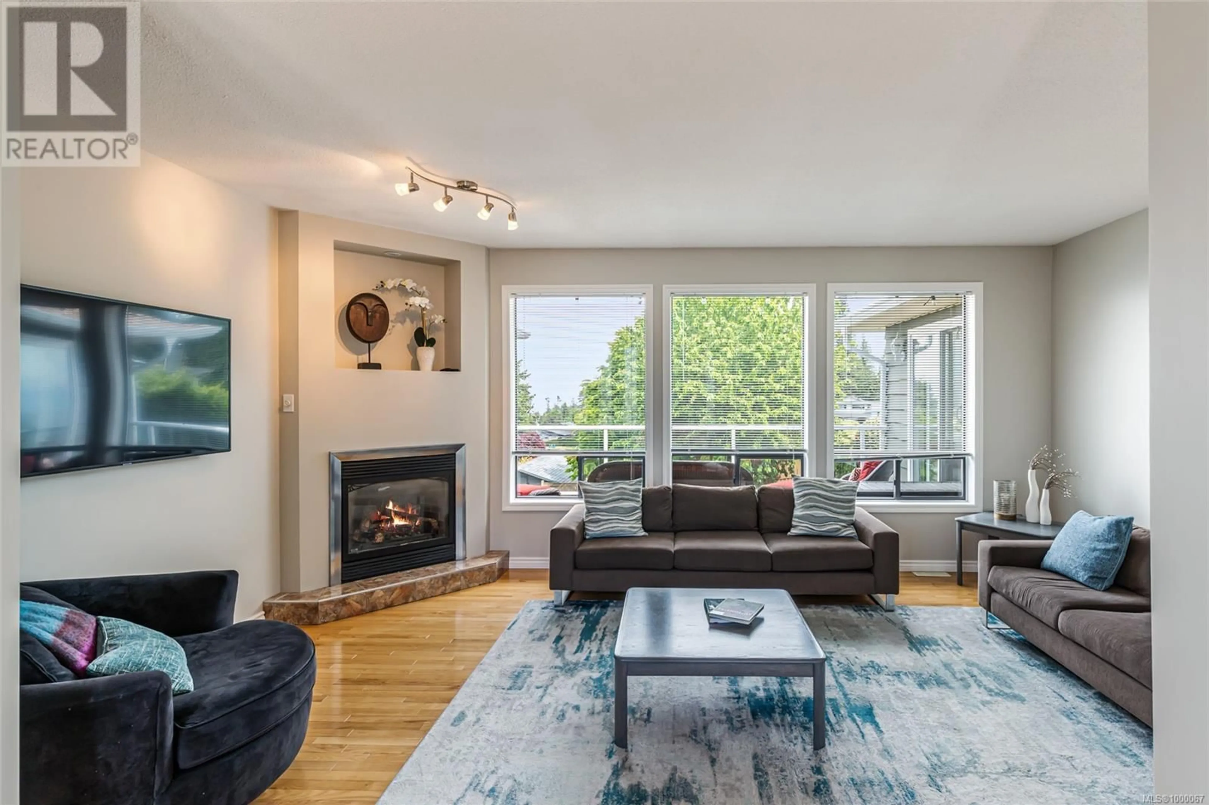 Living room with furniture, wood/laminate floor for 5740 NORASEA ROAD, Nanaimo British Columbia V9V1G6