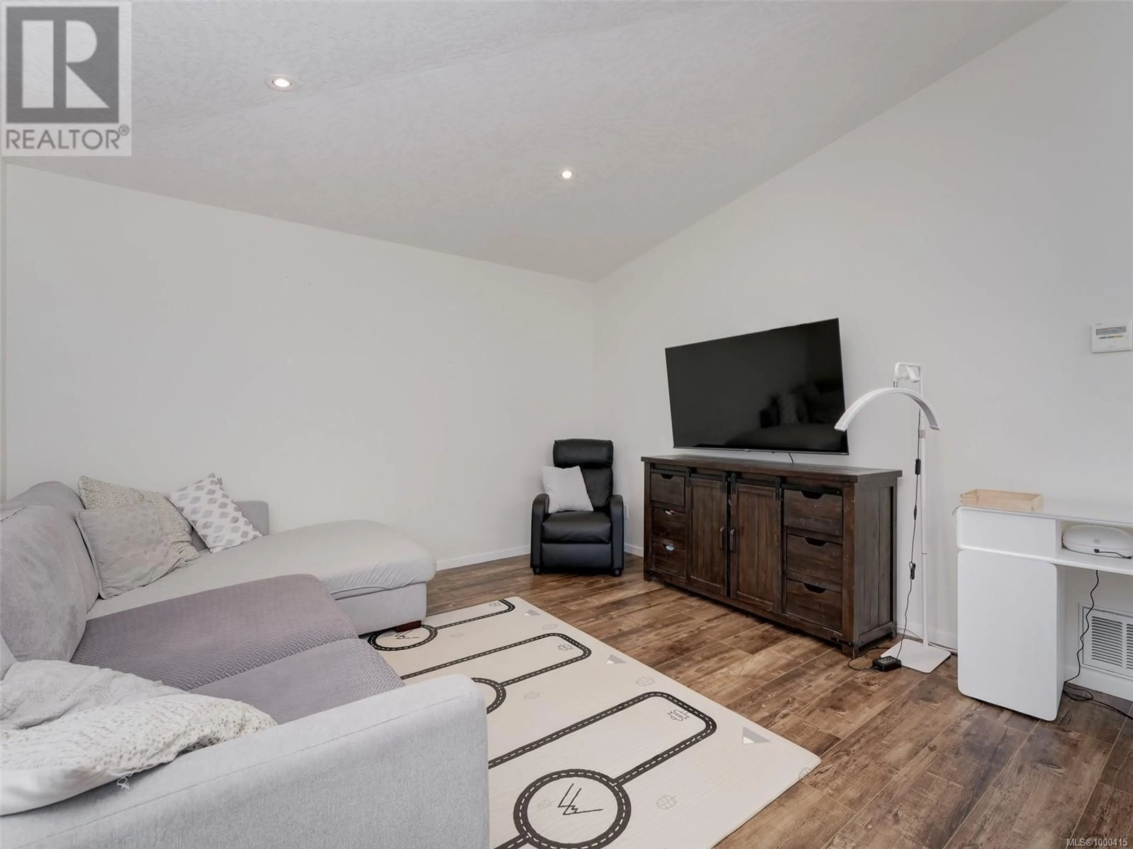 Living room with furniture, wood/laminate floor for 2 - 7650 QWUC CHUS LANE, Central Saanich British Columbia V8M0B4
