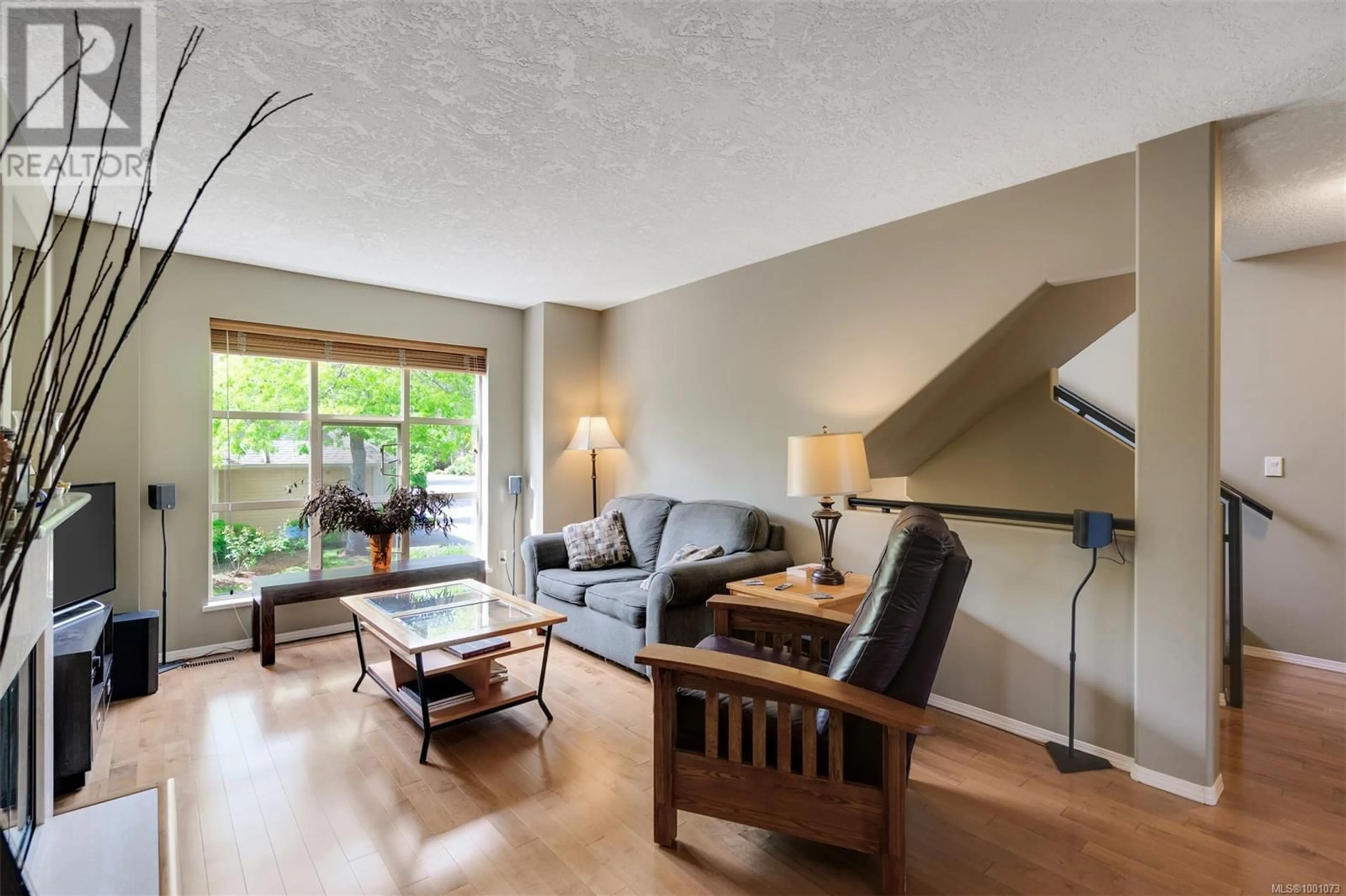 Living room with furniture, wood/laminate floor for 102 - 510 MARSETT PLACE, Saanich British Columbia V8Z7J1