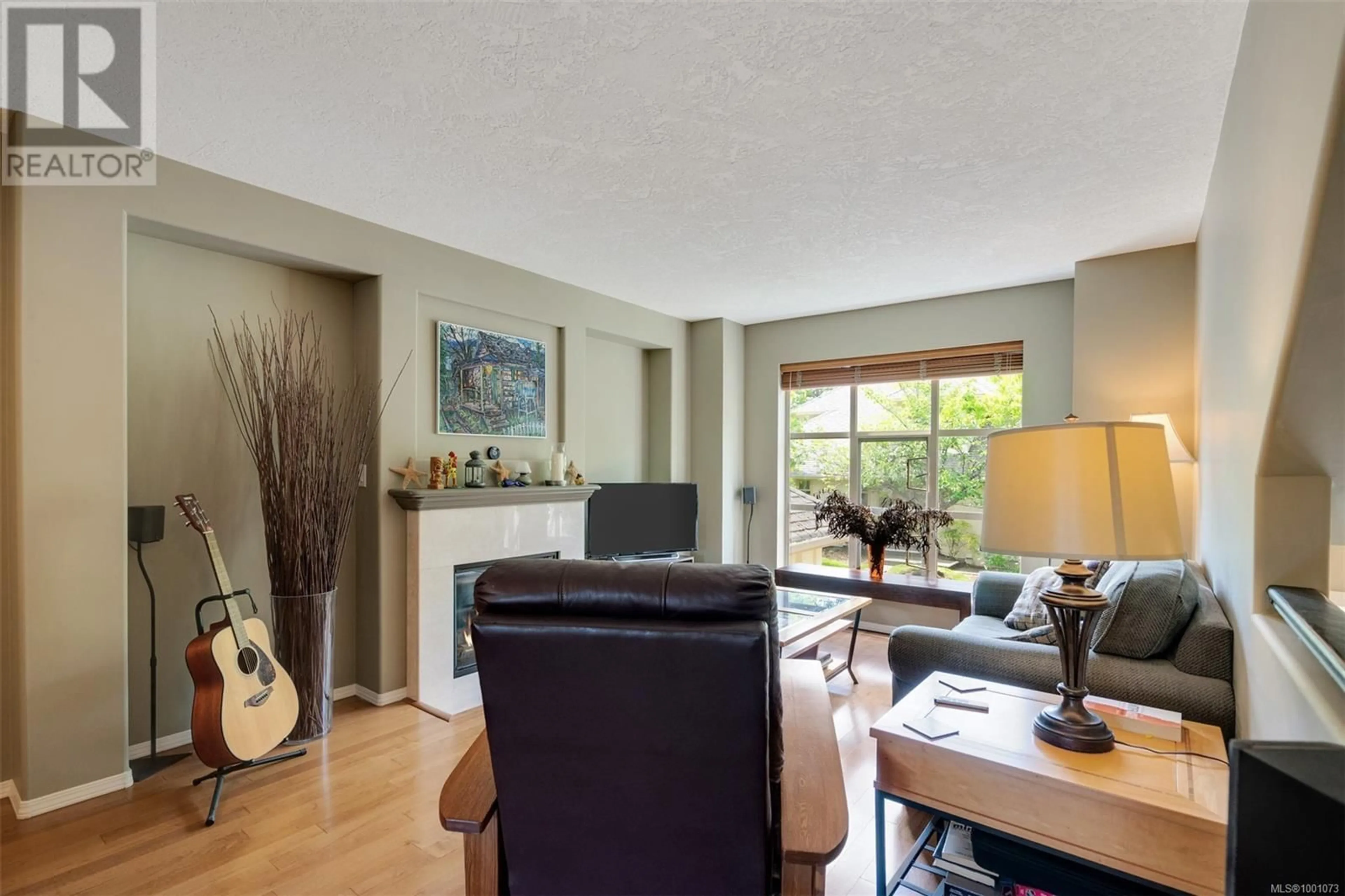 Living room with furniture, wood/laminate floor for 102 - 510 MARSETT PLACE, Saanich British Columbia V8Z7J1