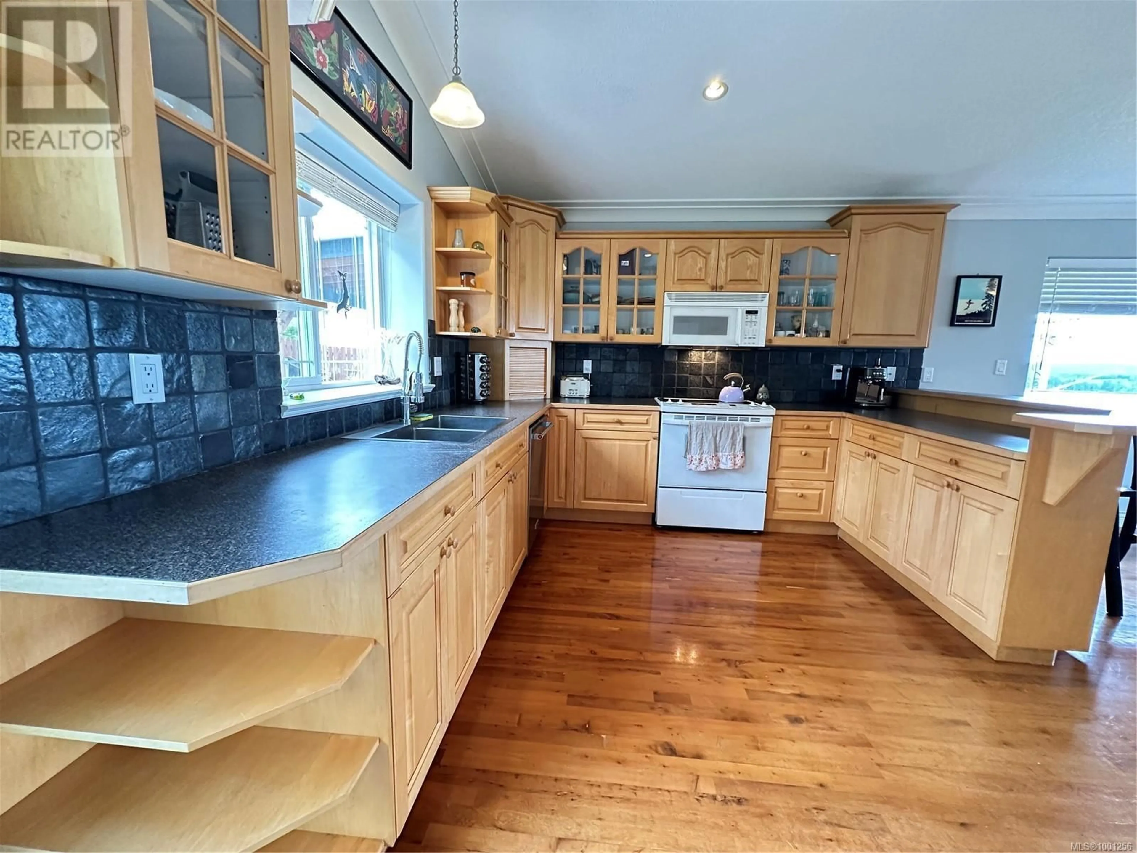 Open concept kitchen, wood/laminate floor for 1865 PIONEER HILL, Port McNeill British Columbia V0N2R0