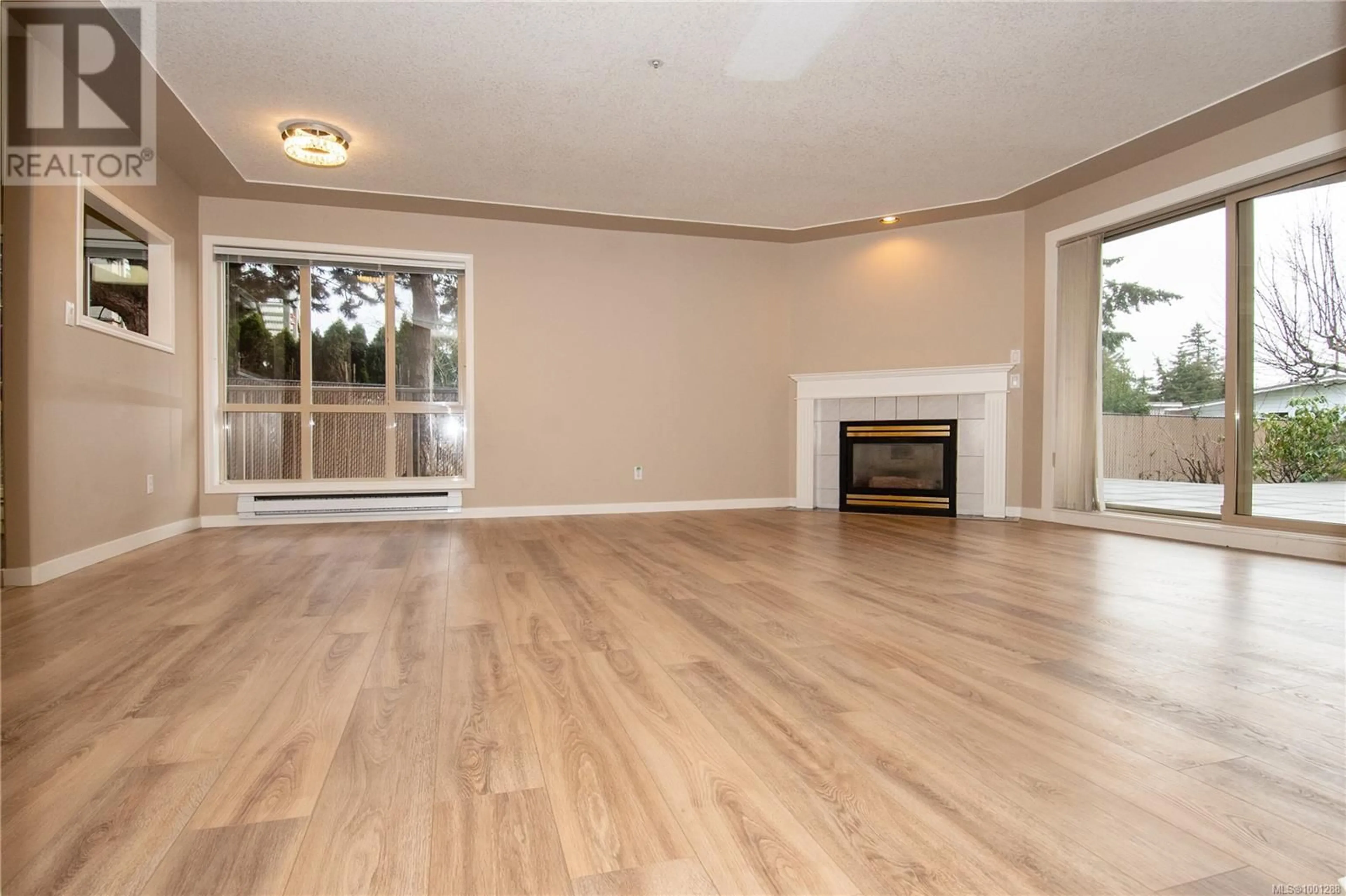 Living room with furniture, wood/laminate floor for 103 - 335 HIRST AVENUE WEST, Parksville British Columbia V9P1K4