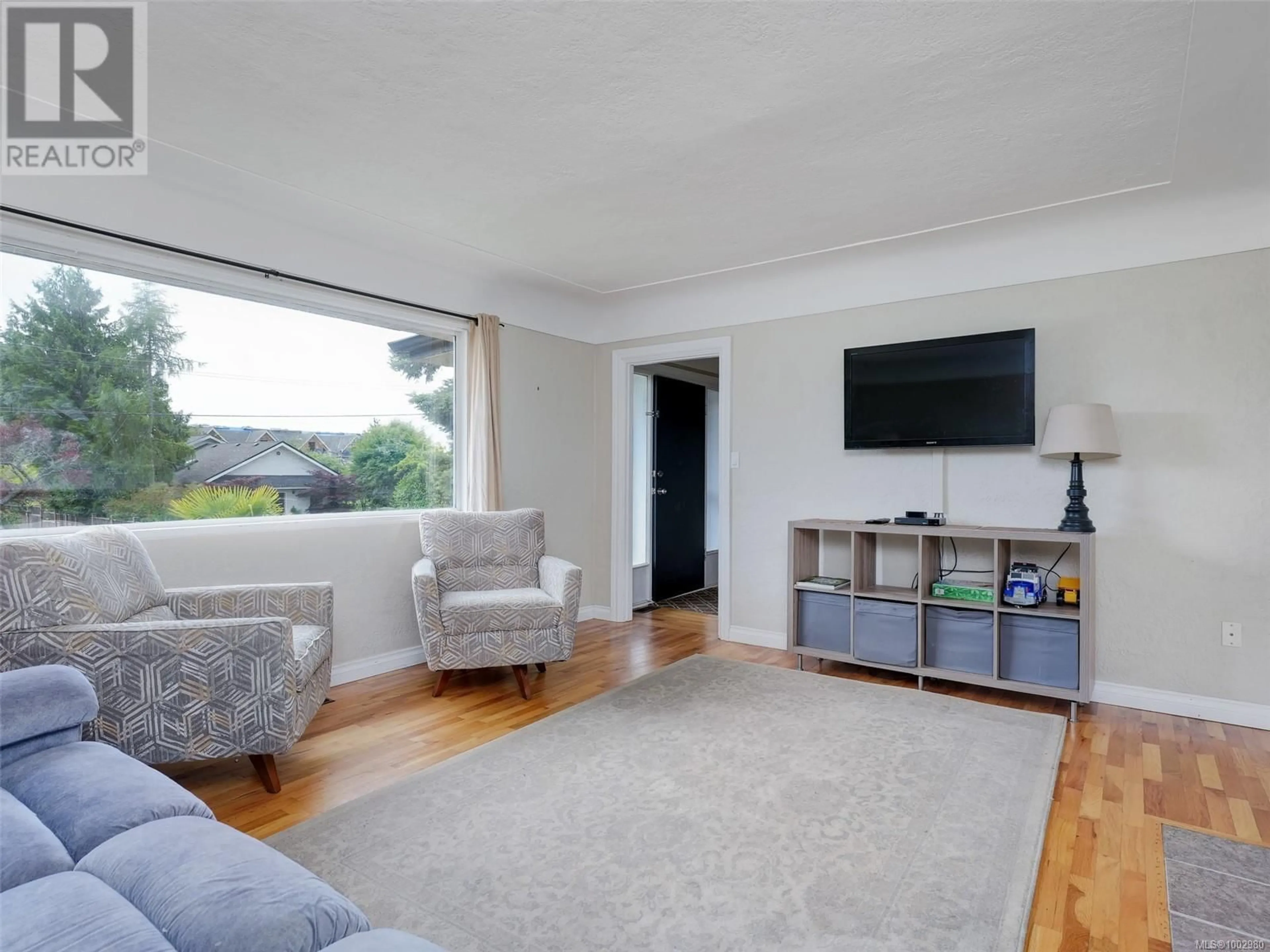Living room with furniture, wood/laminate floor for 1856 NEIL STREET, Saanich British Columbia V8R3C7