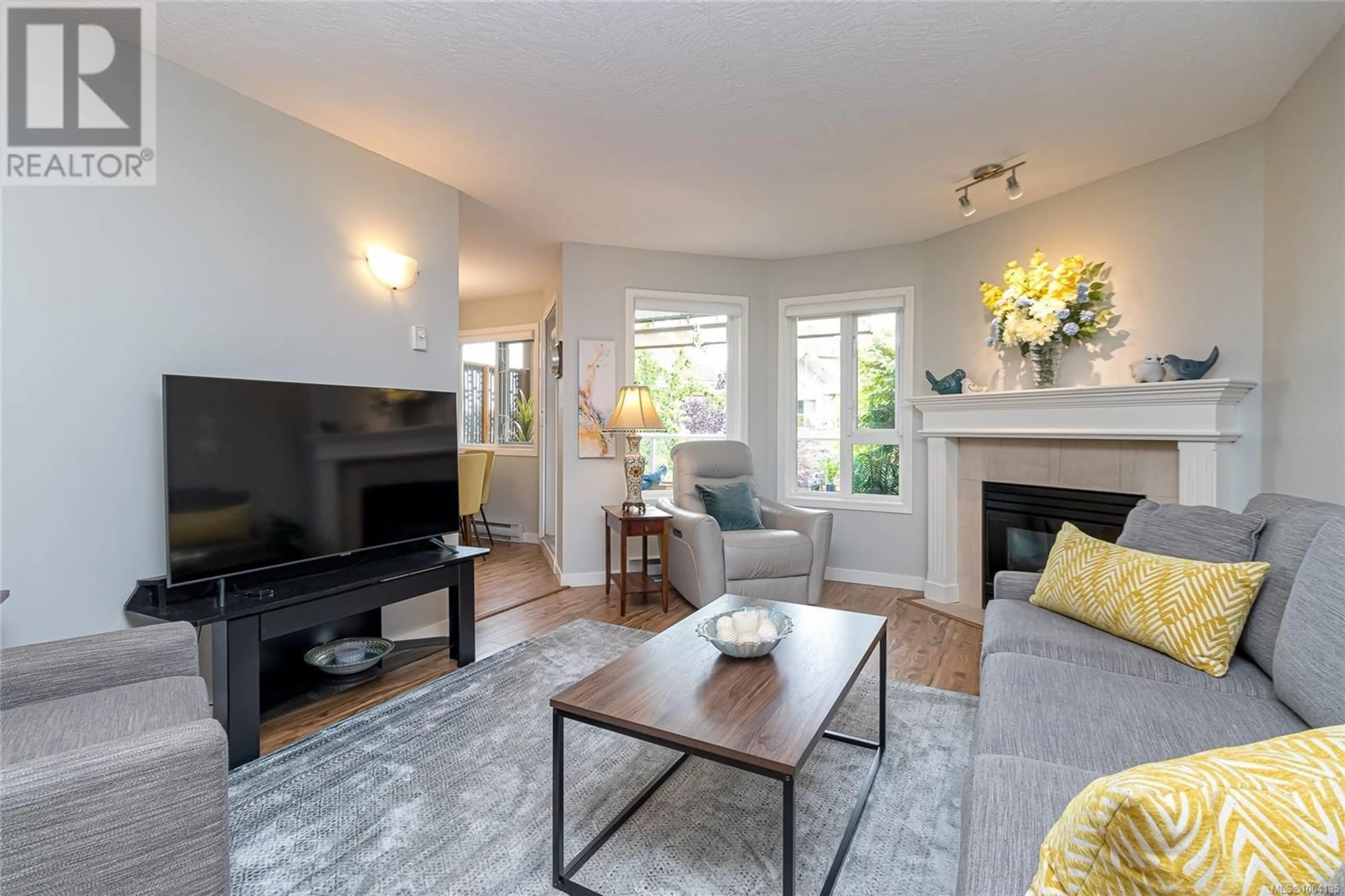 Living room with furniture, wood/laminate floor for 311 - 490 MARSETT PLACE, Saanich British Columbia V8Z7J2