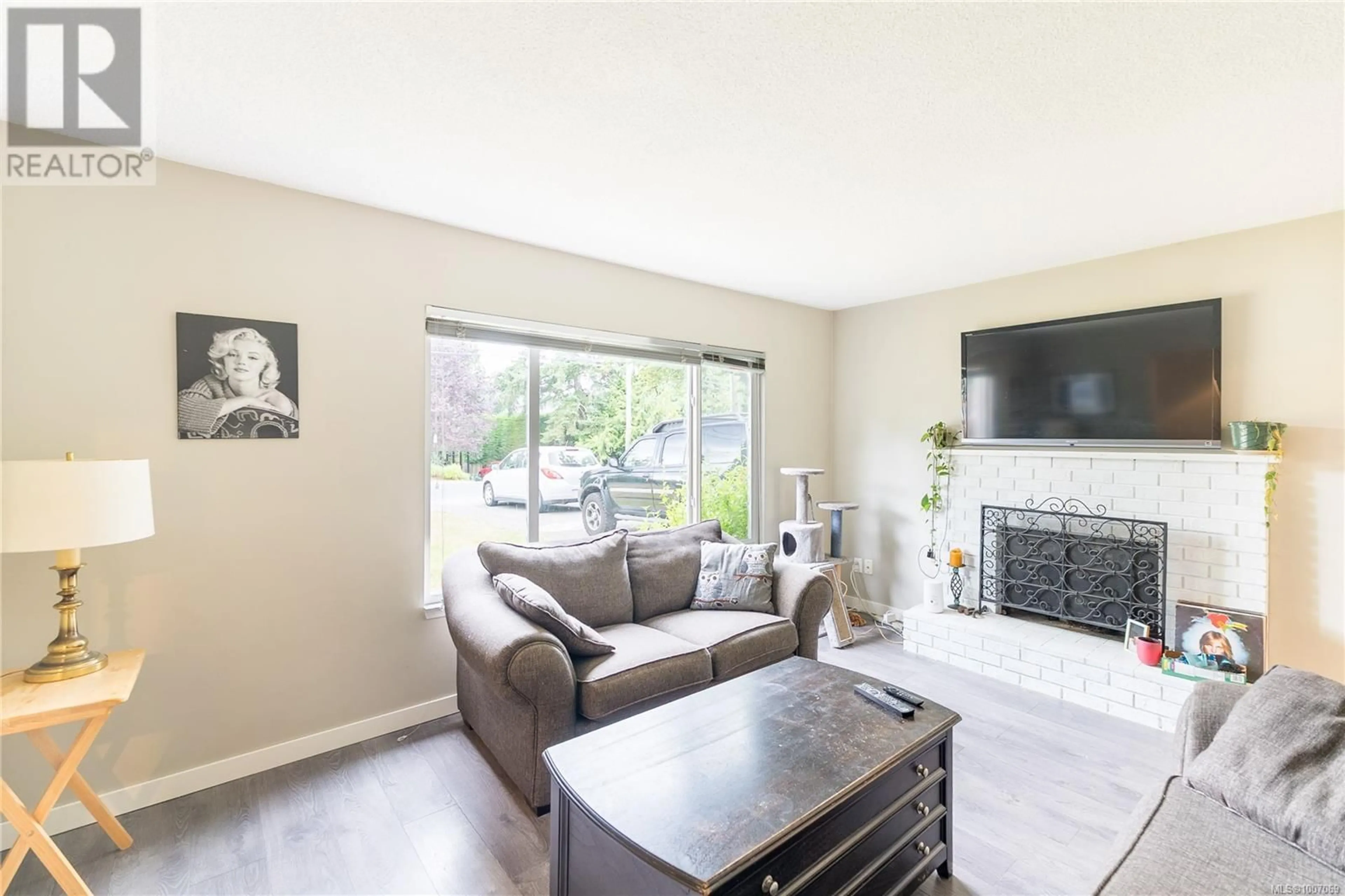 Living room with furniture, wood/laminate floor for 1068 CLARKE ROAD, Central Saanich British Columbia V8M1C7