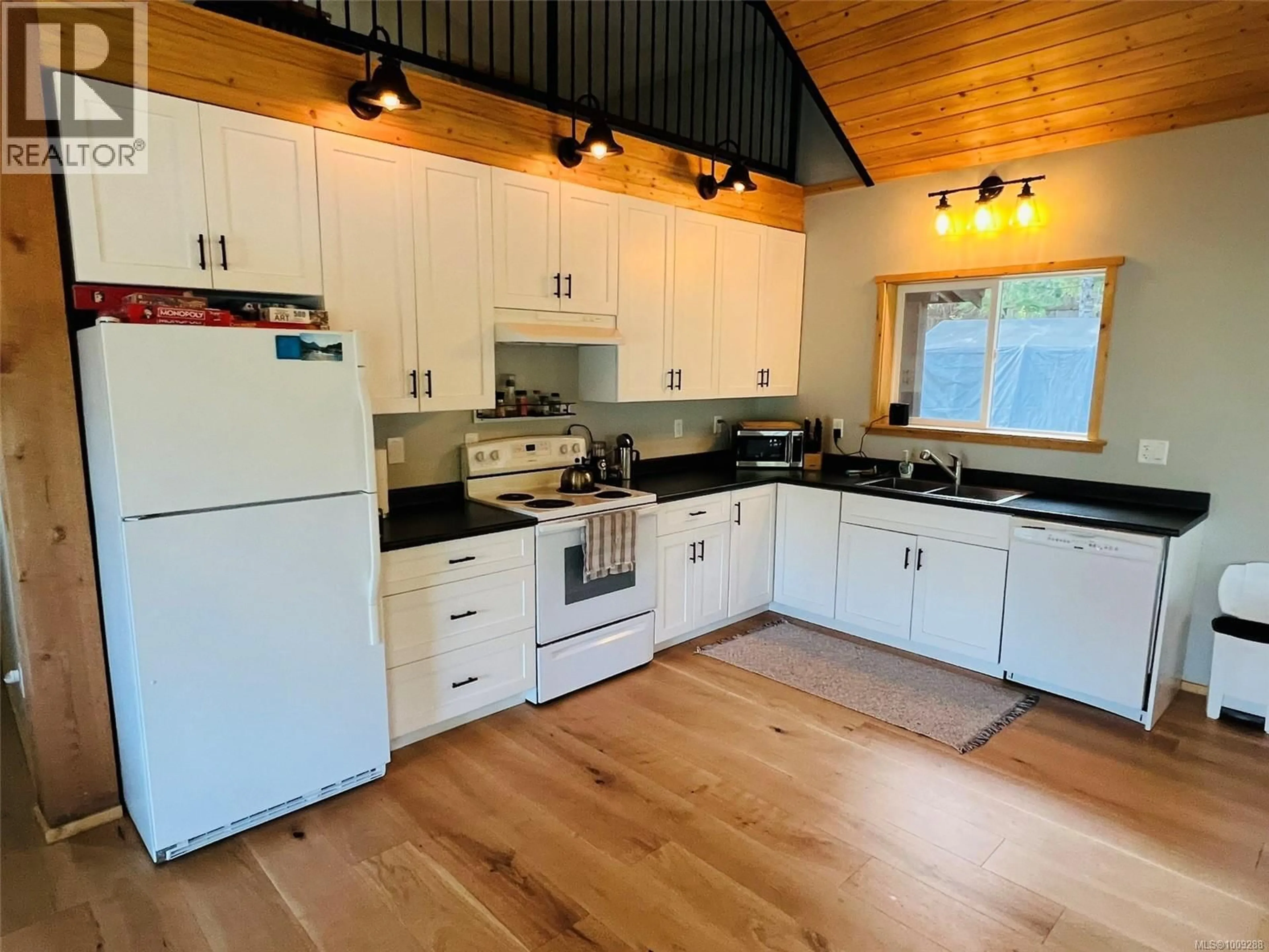 Open concept kitchen, wood/laminate floor for 28 HOOMAK AVENUE, Woss British Columbia V0N3P0