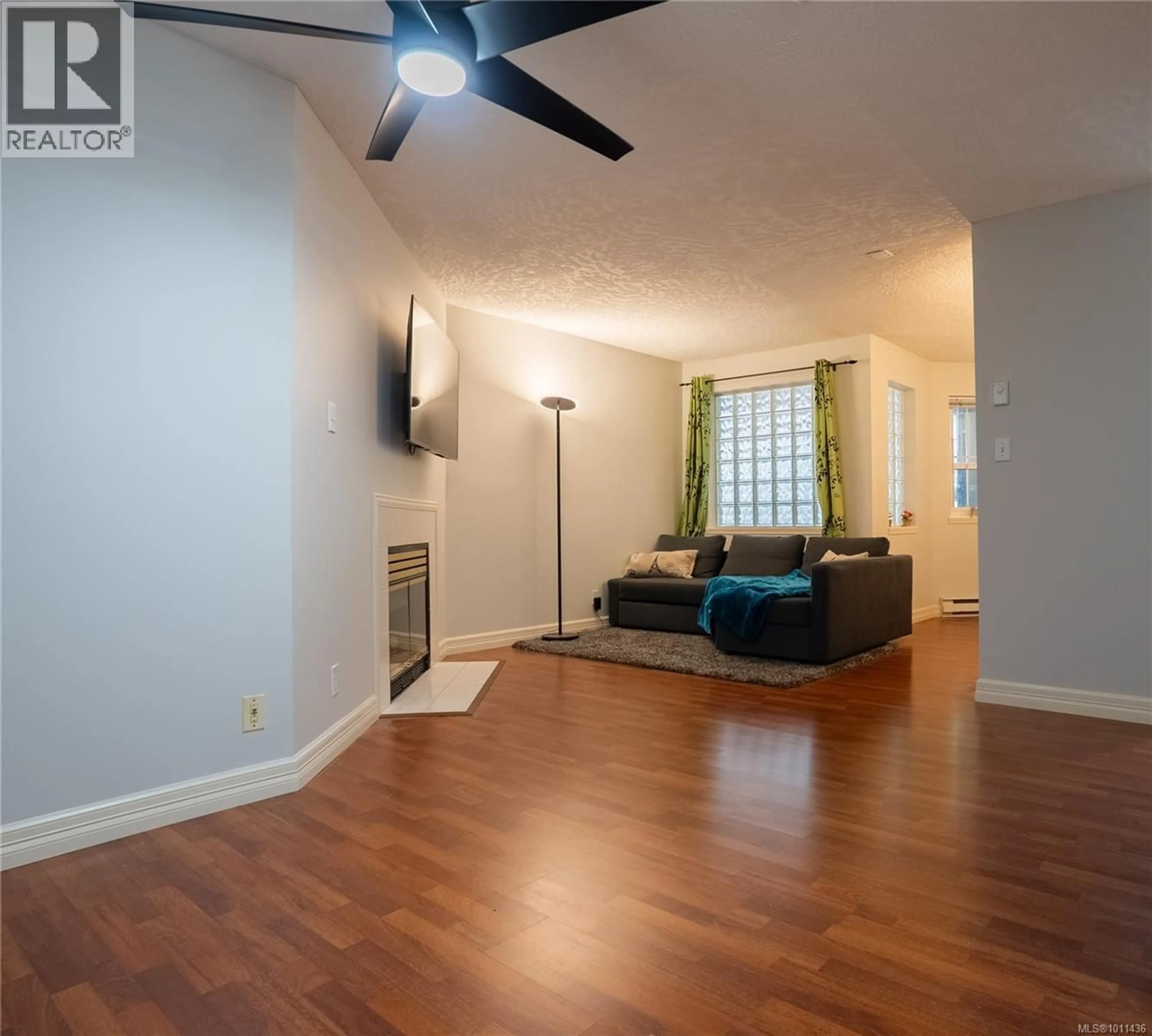 Living room with furniture, wood/laminate floor for 101 - 2710 GROSVENOR ROAD, Victoria British Columbia V8T3M9