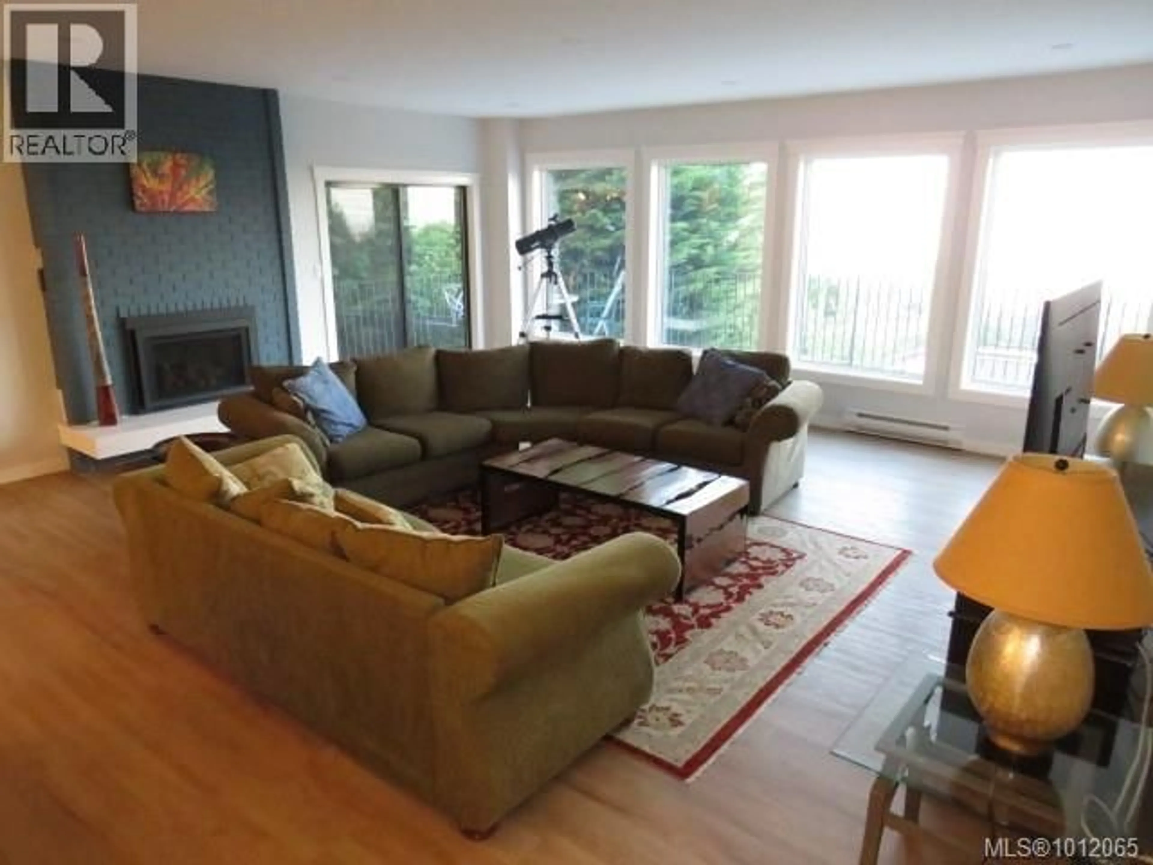 Living room with furniture, wood/laminate floor for 8870 FOREST PARK DRIVE, North Saanich British Columbia V8L4E9