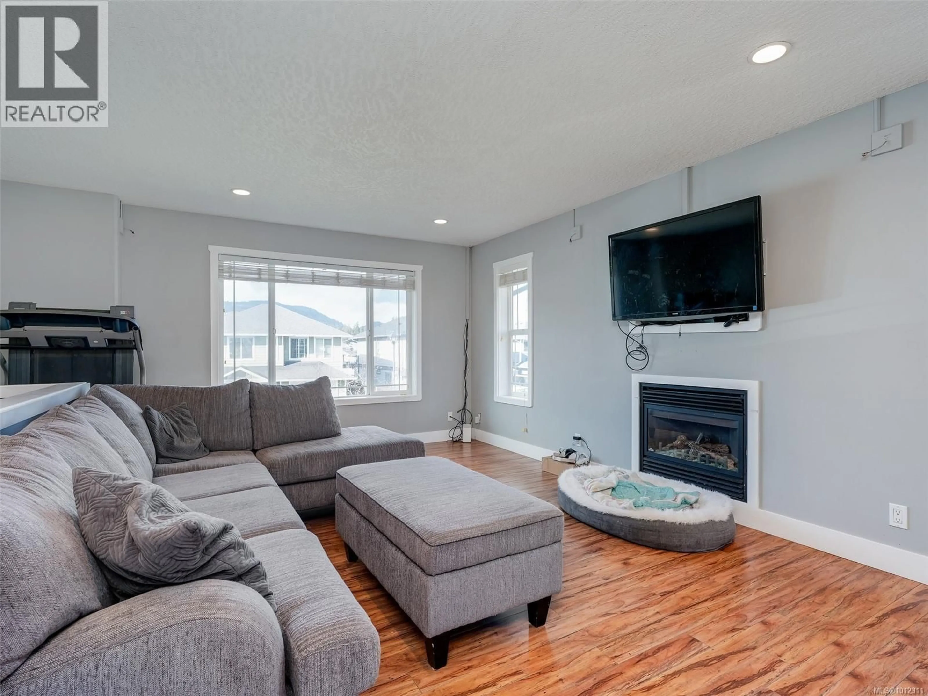 Living room with furniture, wood/laminate floor for 6753 STEEPLE CHASE, Sooke British Columbia V9Z0W3