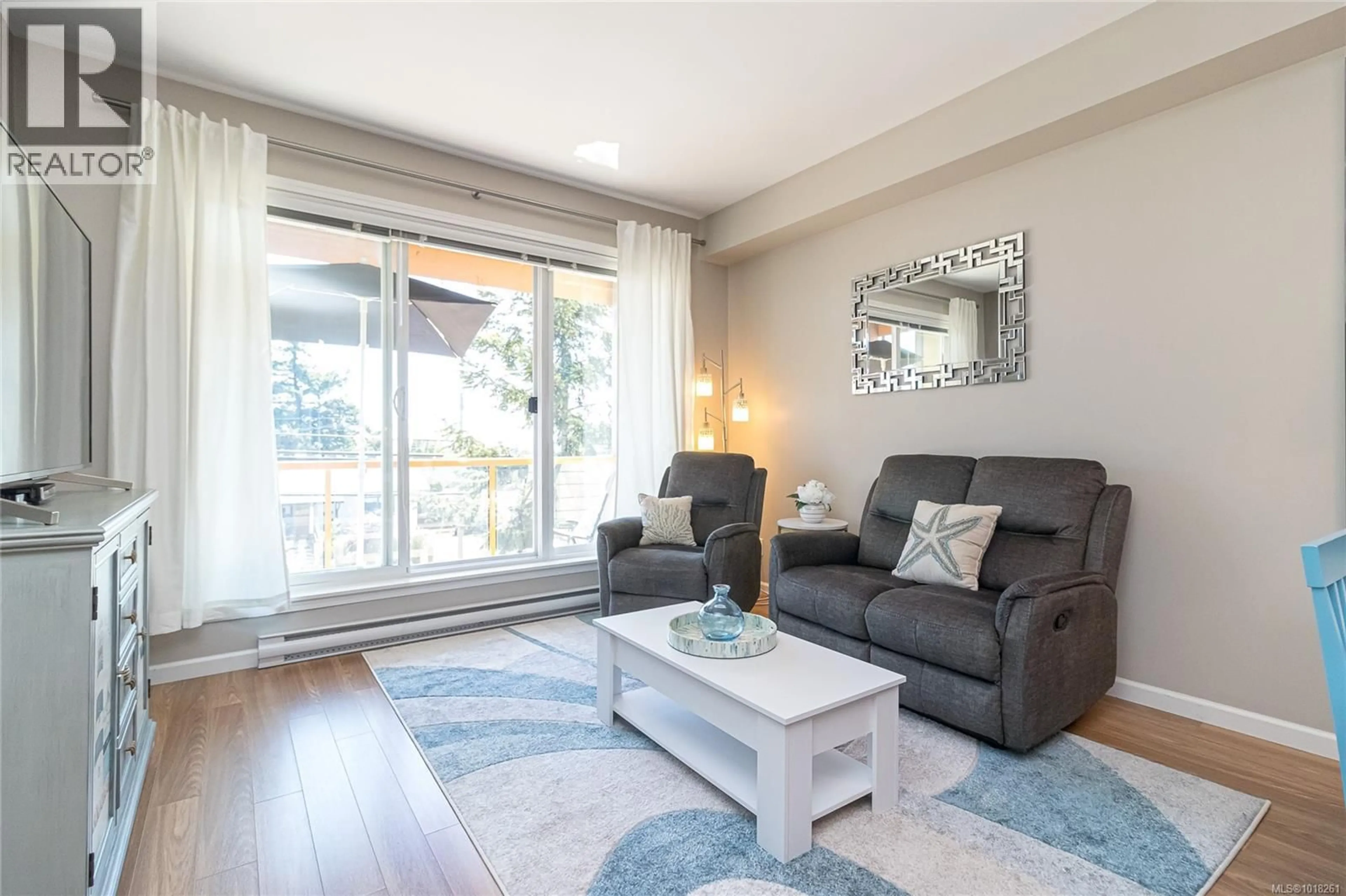 Living room with furniture, wood/laminate floor for 210 - 1959 POLO PARK COURT, Central Saanich British Columbia V8M2K1