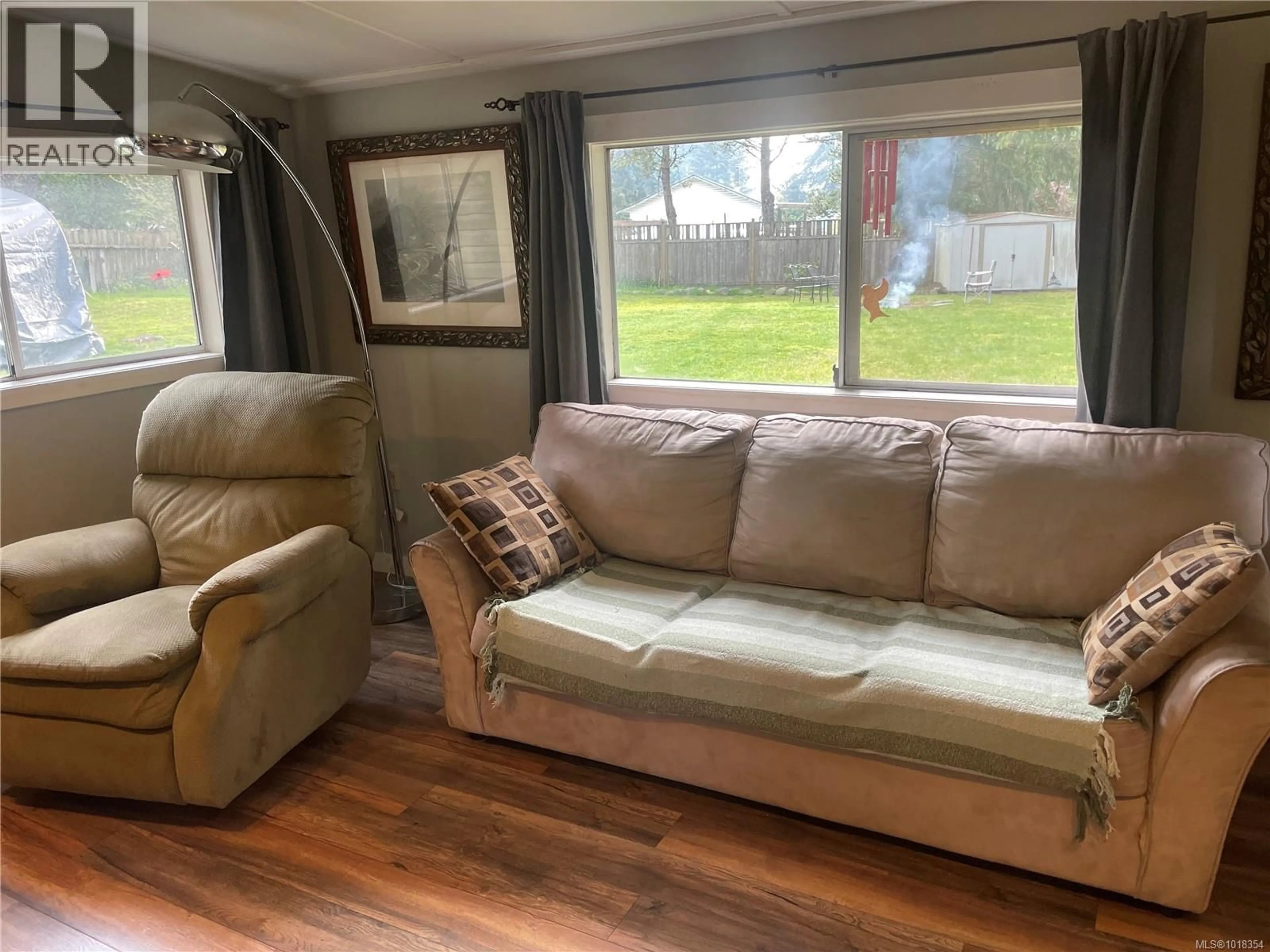 Living room with furniture, wood/laminate floor for 247 HUSON ROAD, Qualicum Beach British Columbia V9K2A2