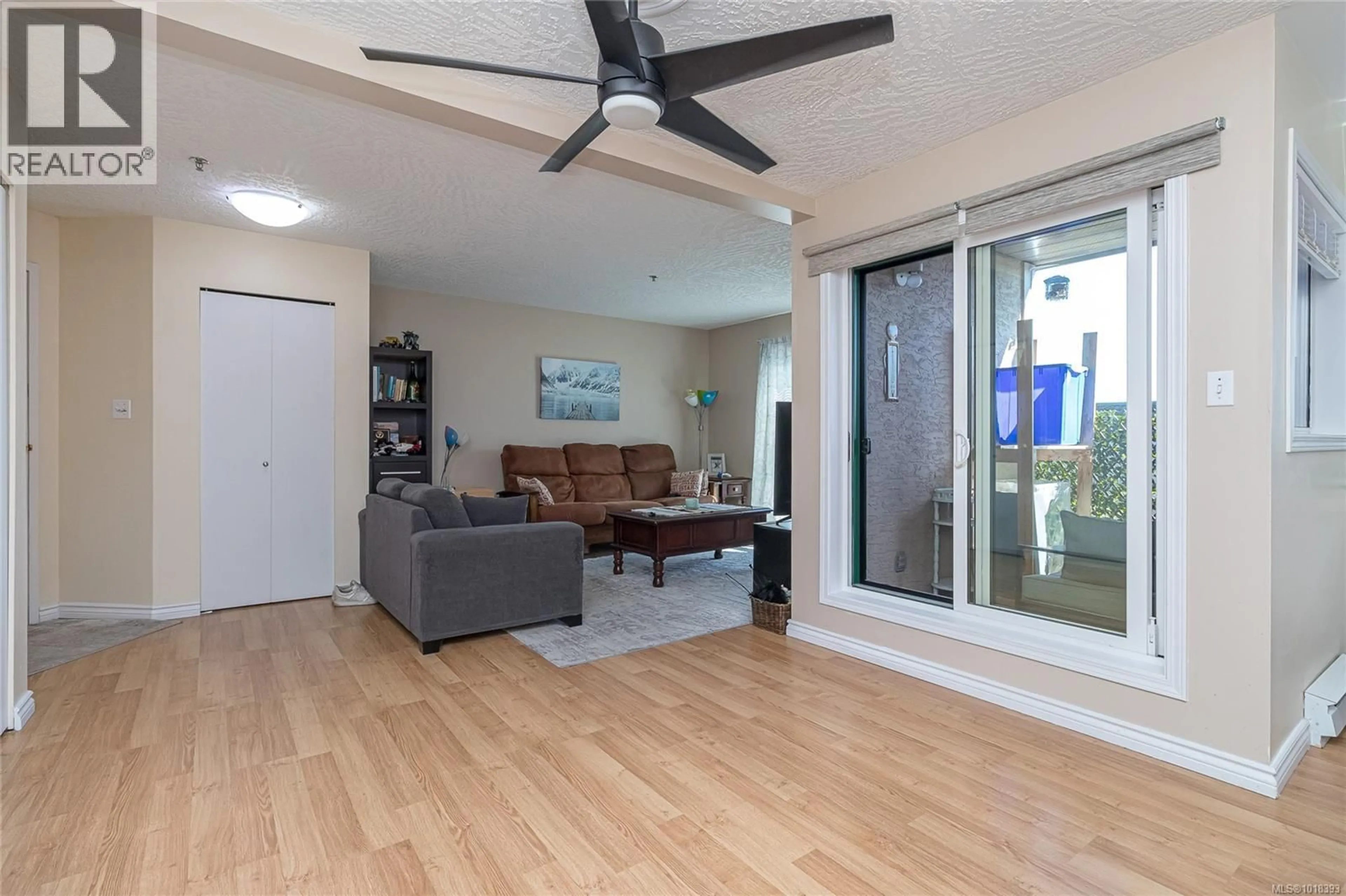 Living room with furniture, wood/laminate floor for 312 - 3460 QUADRA STREET, Saanich British Columbia V8X1G6