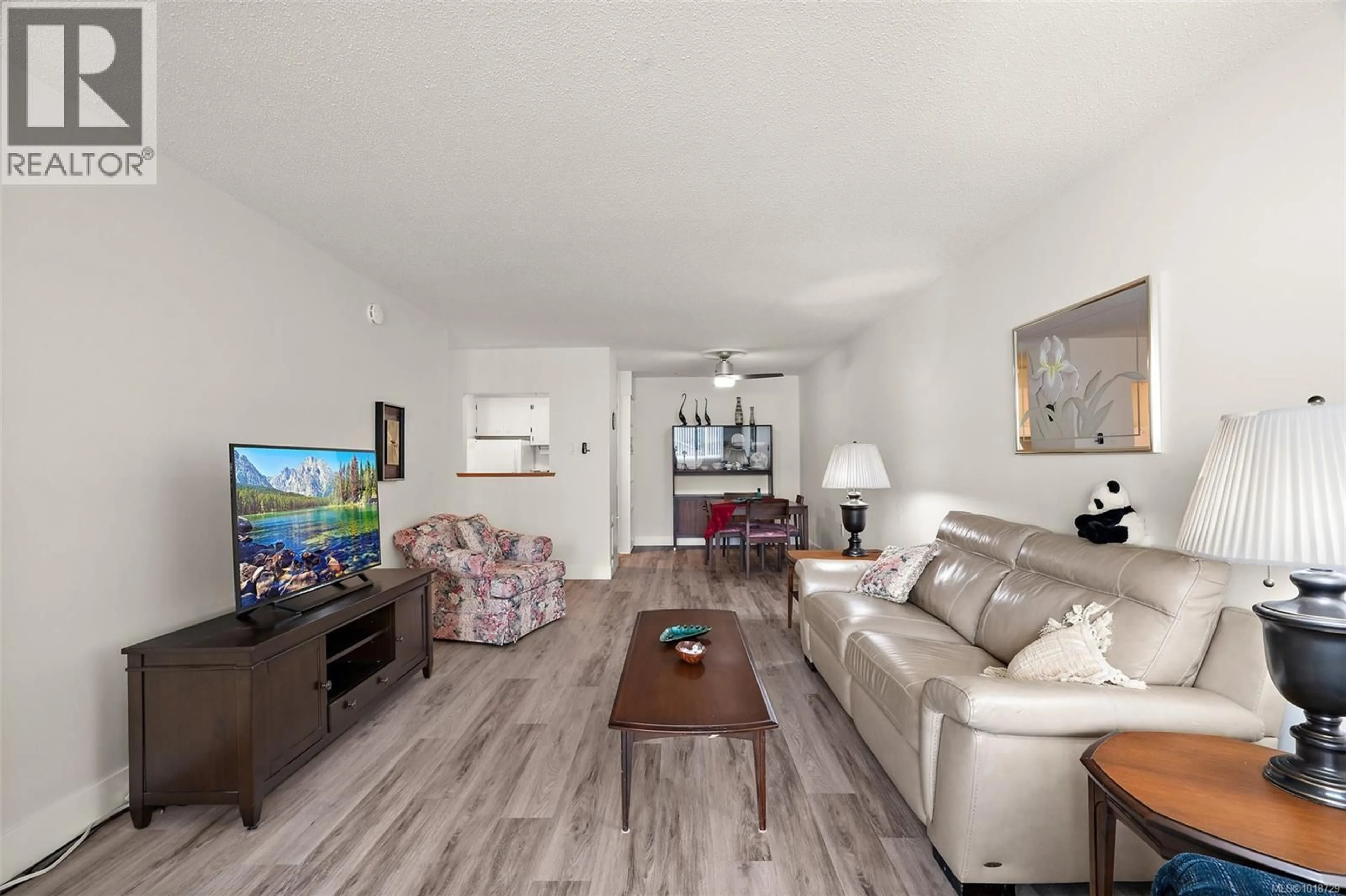 Living room with furniture, wood/laminate floor for 206 - 2050 WHITE BIRCH ROAD, Sidney British Columbia V8L2R2