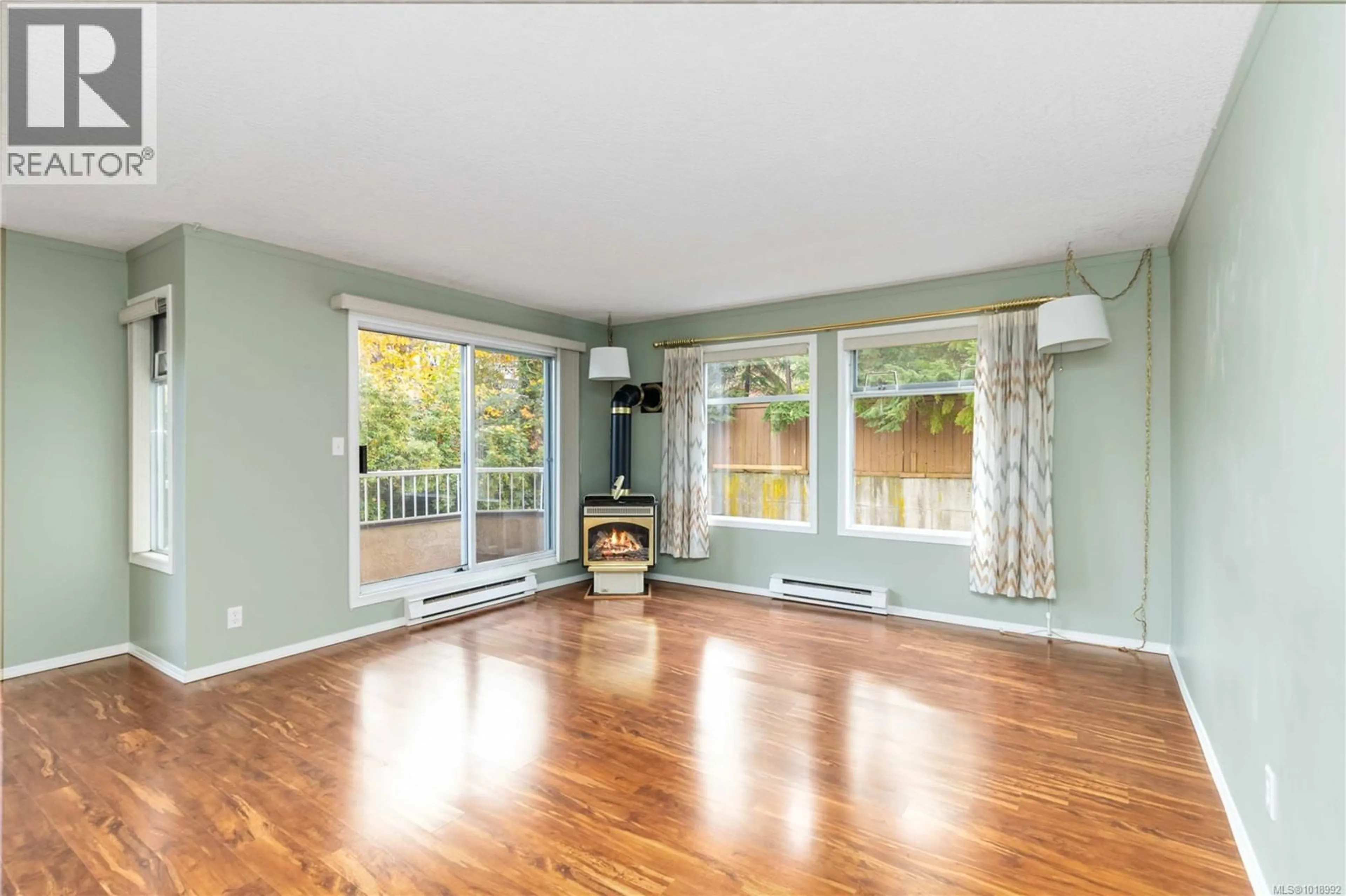 Living room with furniture, wood/laminate floor for 104 - 3263 ALDER STREET, Victoria British Columbia V8X1P3