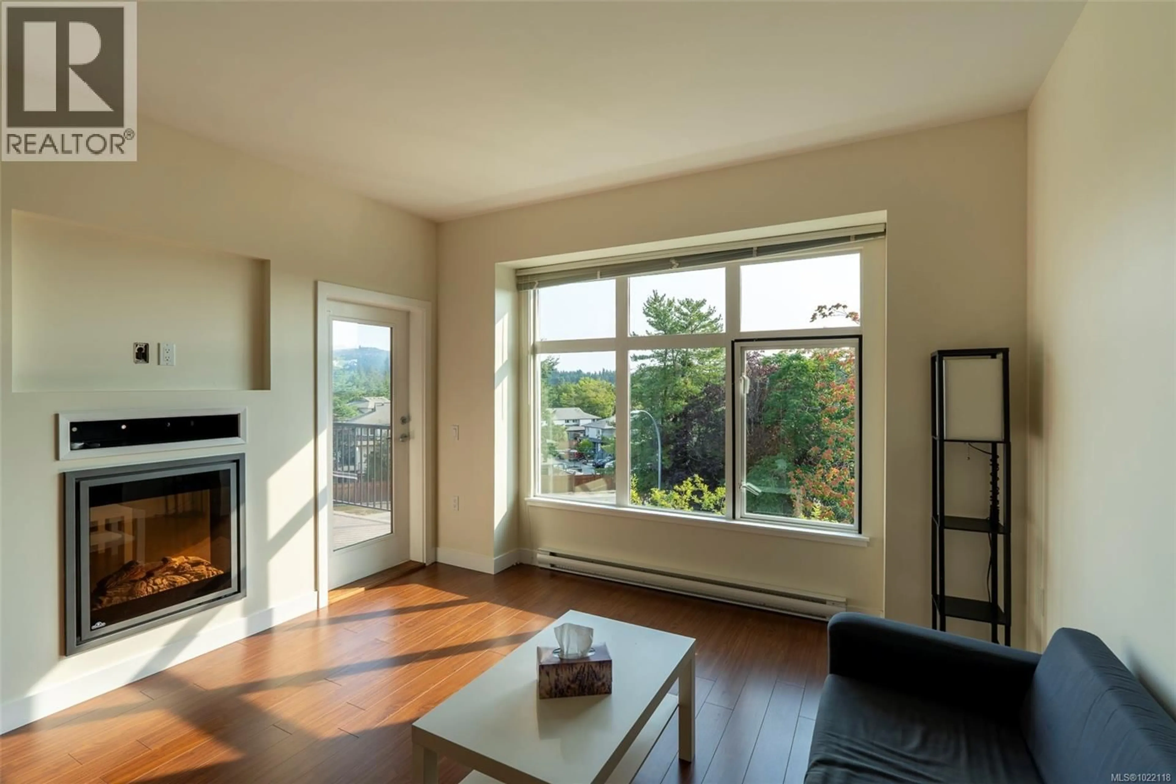 Living room with furniture, wood/laminate floor for 402 - 4030 BORDEN STREET, Saanich British Columbia V8X2E9