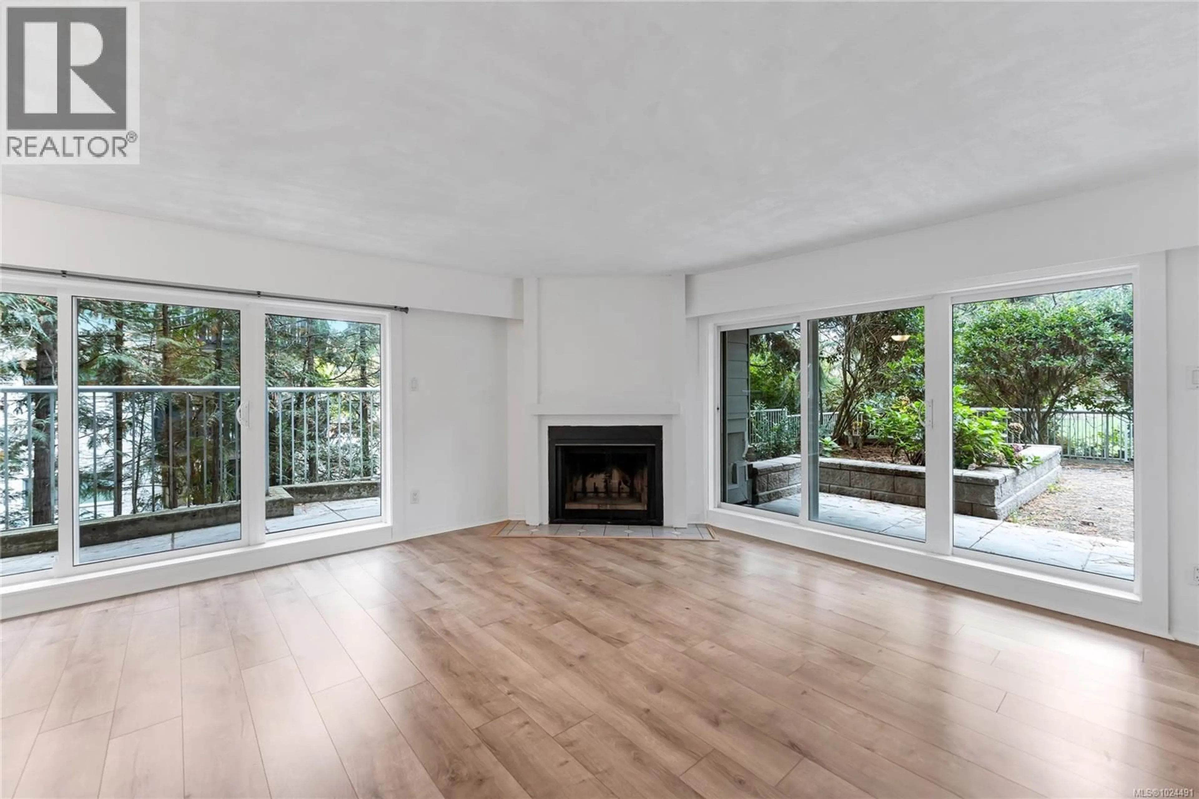 Living room with furniture, wood/laminate floor for 105 - 3277 QUADRA STREET, Saanich British Columbia V8X4W9