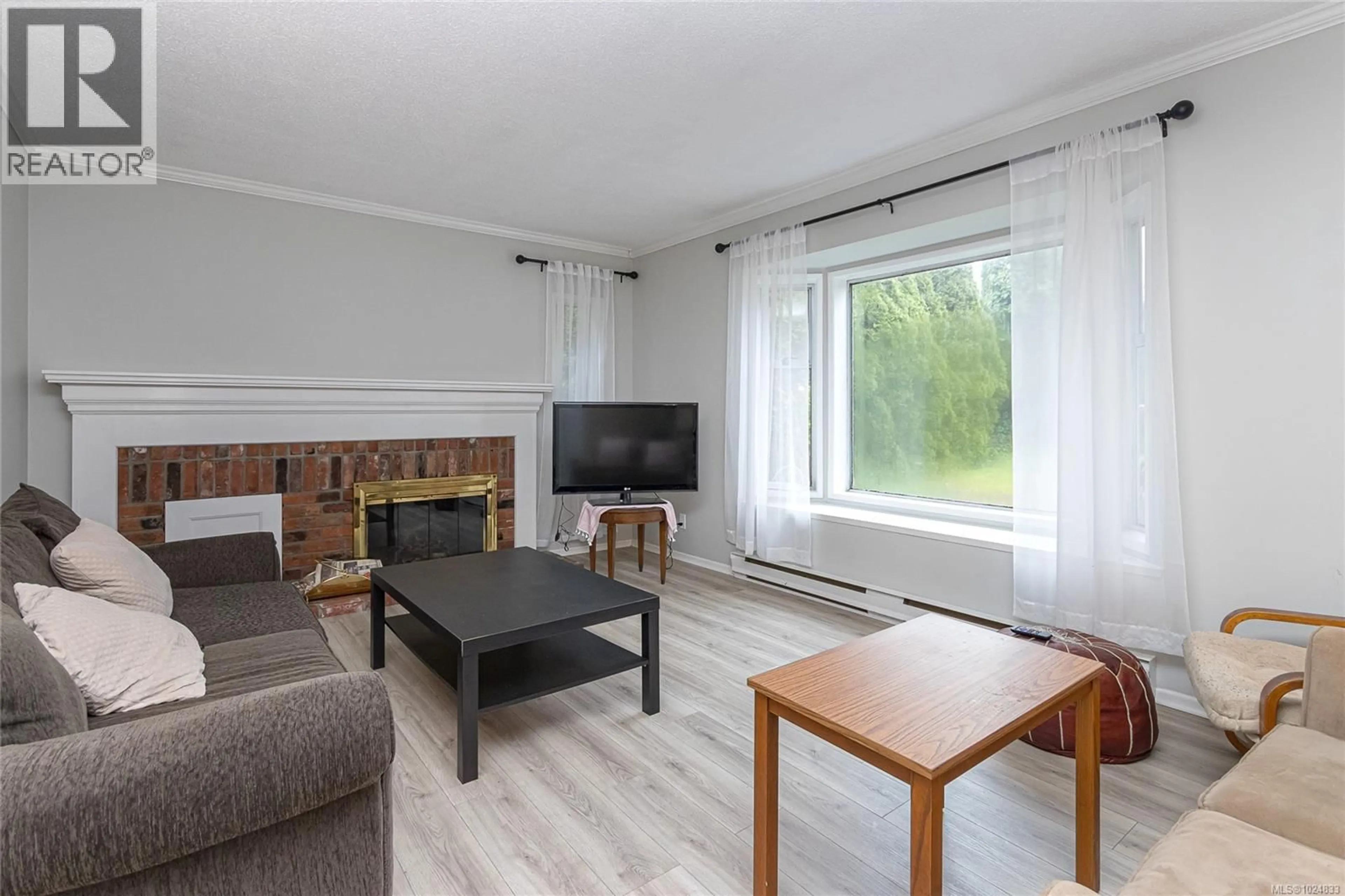Living room with furniture, wood/laminate floor for 2589 SINCLAIR ROAD, Saanich British Columbia V8N1C1