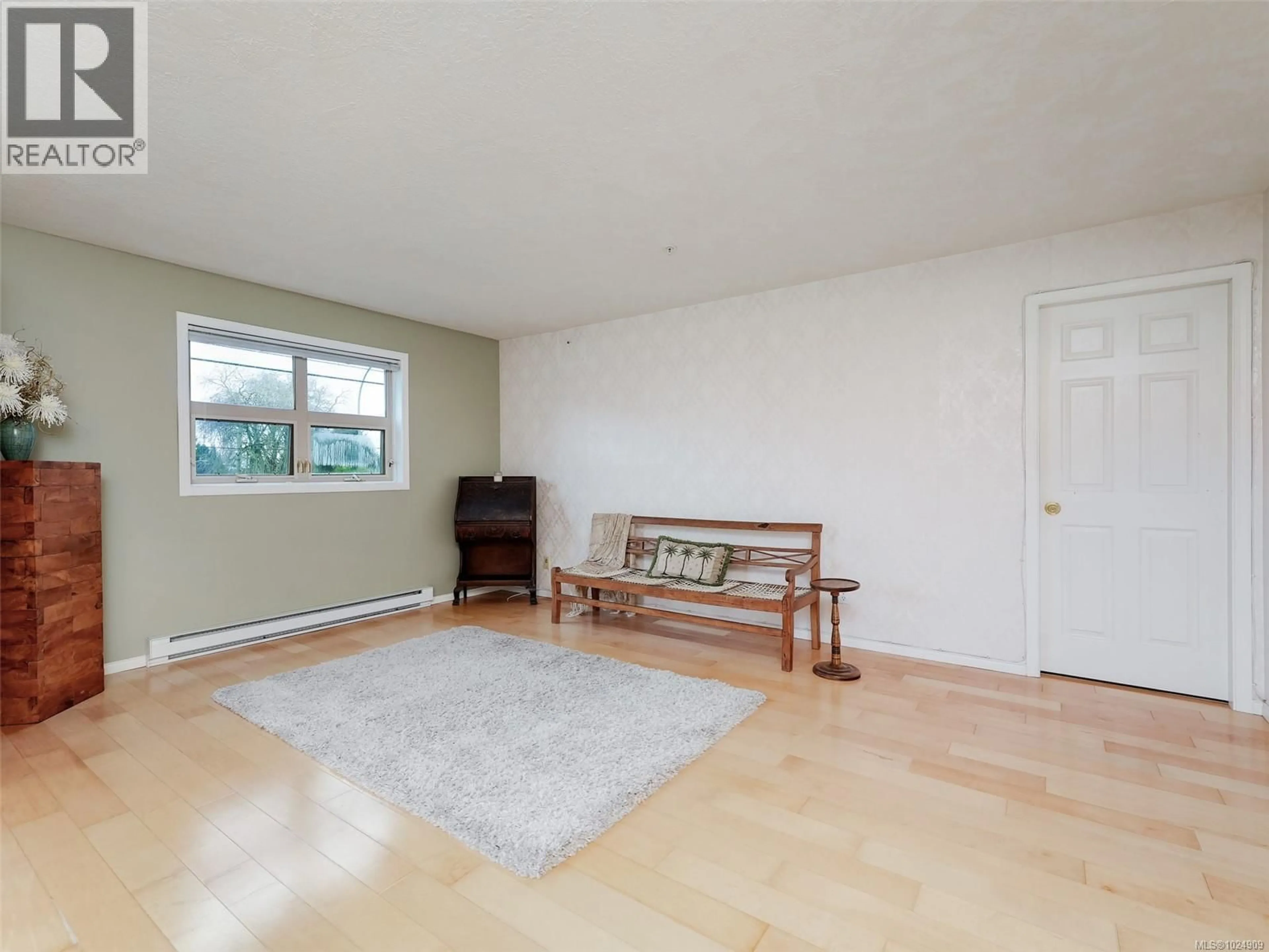 Living room with furniture, wood/laminate floor for 202 - 1694 CEDAR HILL CROSS ROAD, Saanich British Columbia V8P2P7