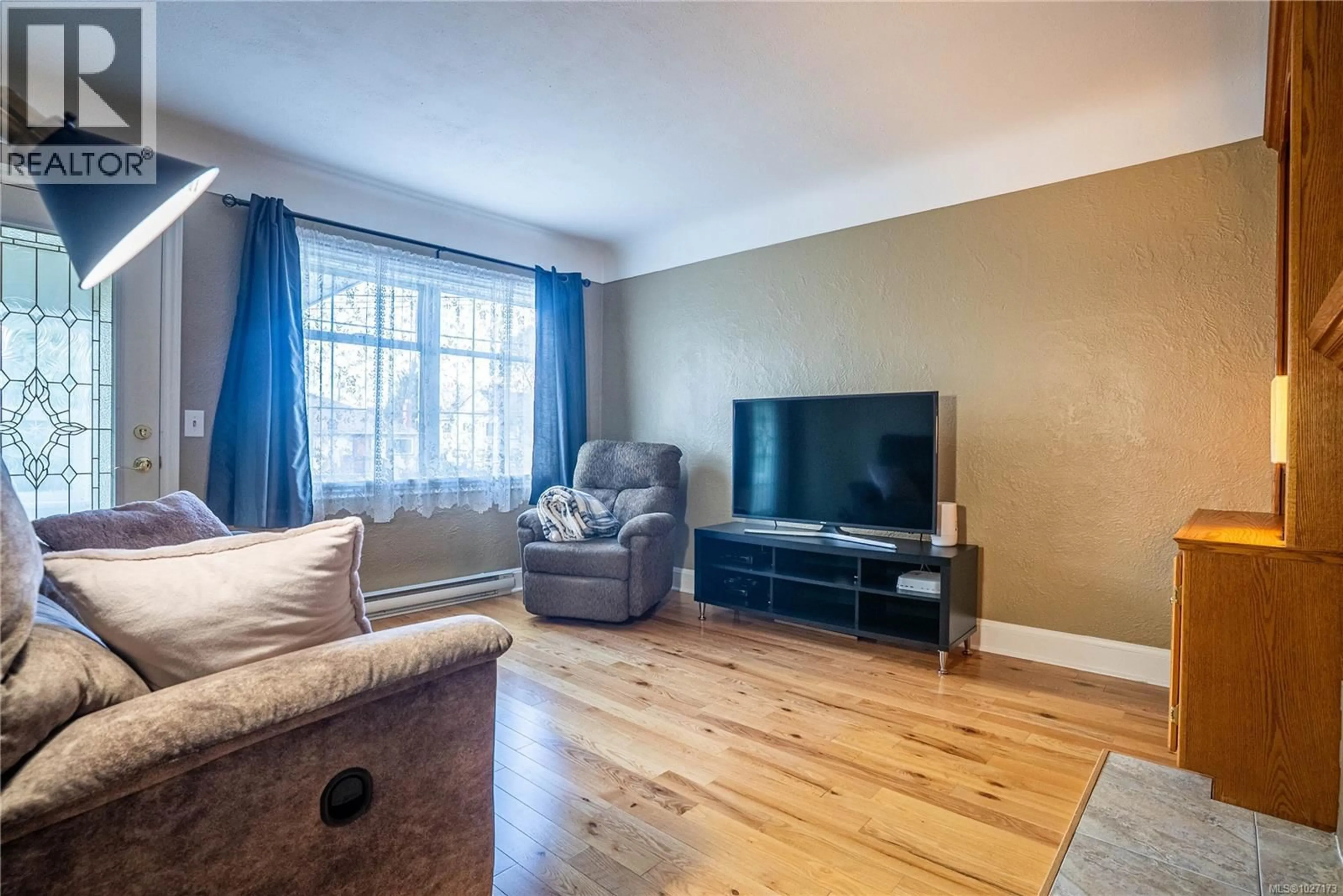 Living room with furniture, wood/laminate floor for 3165 WASCANA STREET, Saanich British Columbia V9A1W4