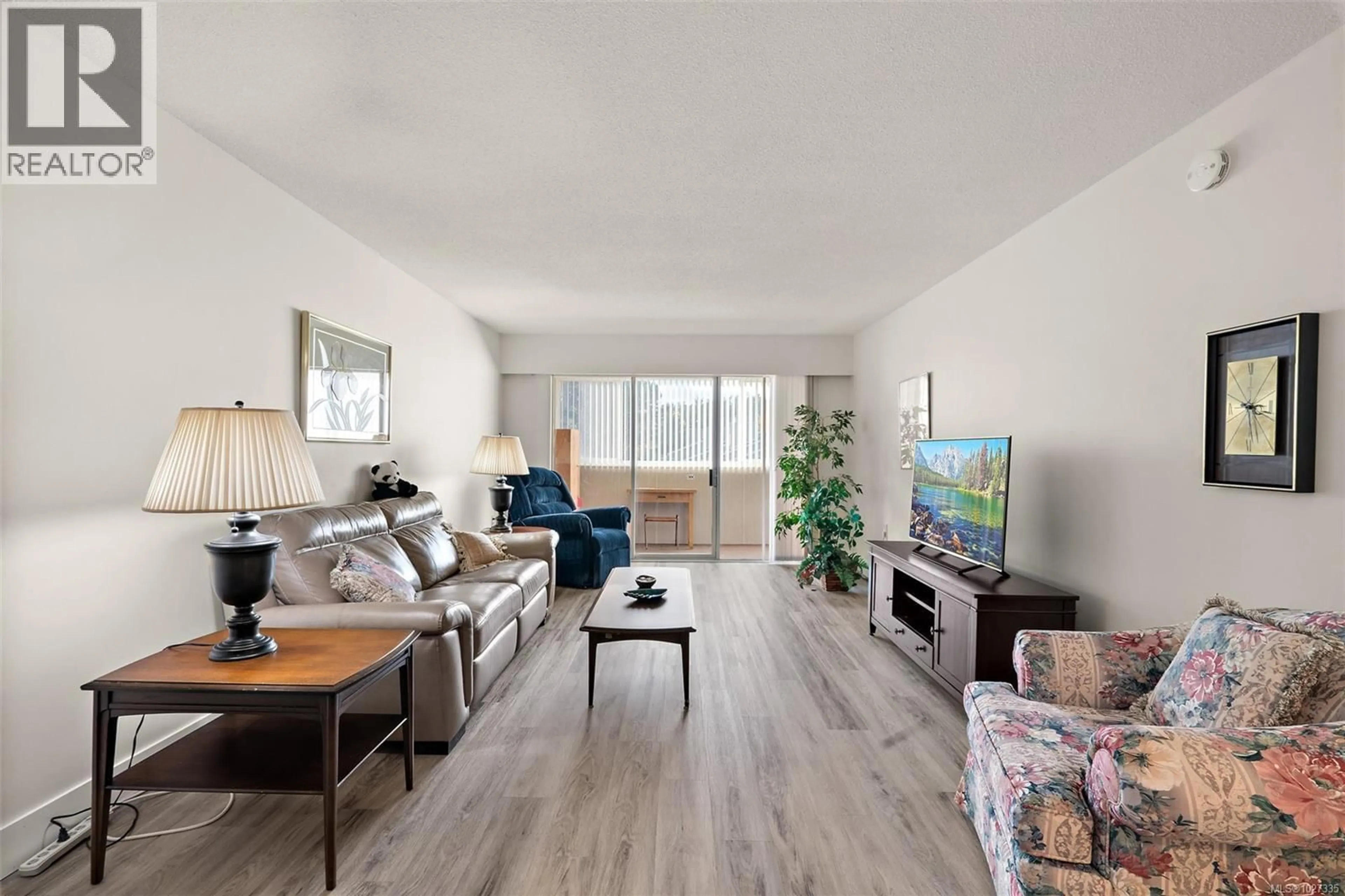 Living room with furniture, wood/laminate floor for 206 - 2050 WHITE BIRCH ROAD, Sidney British Columbia V8L2R2