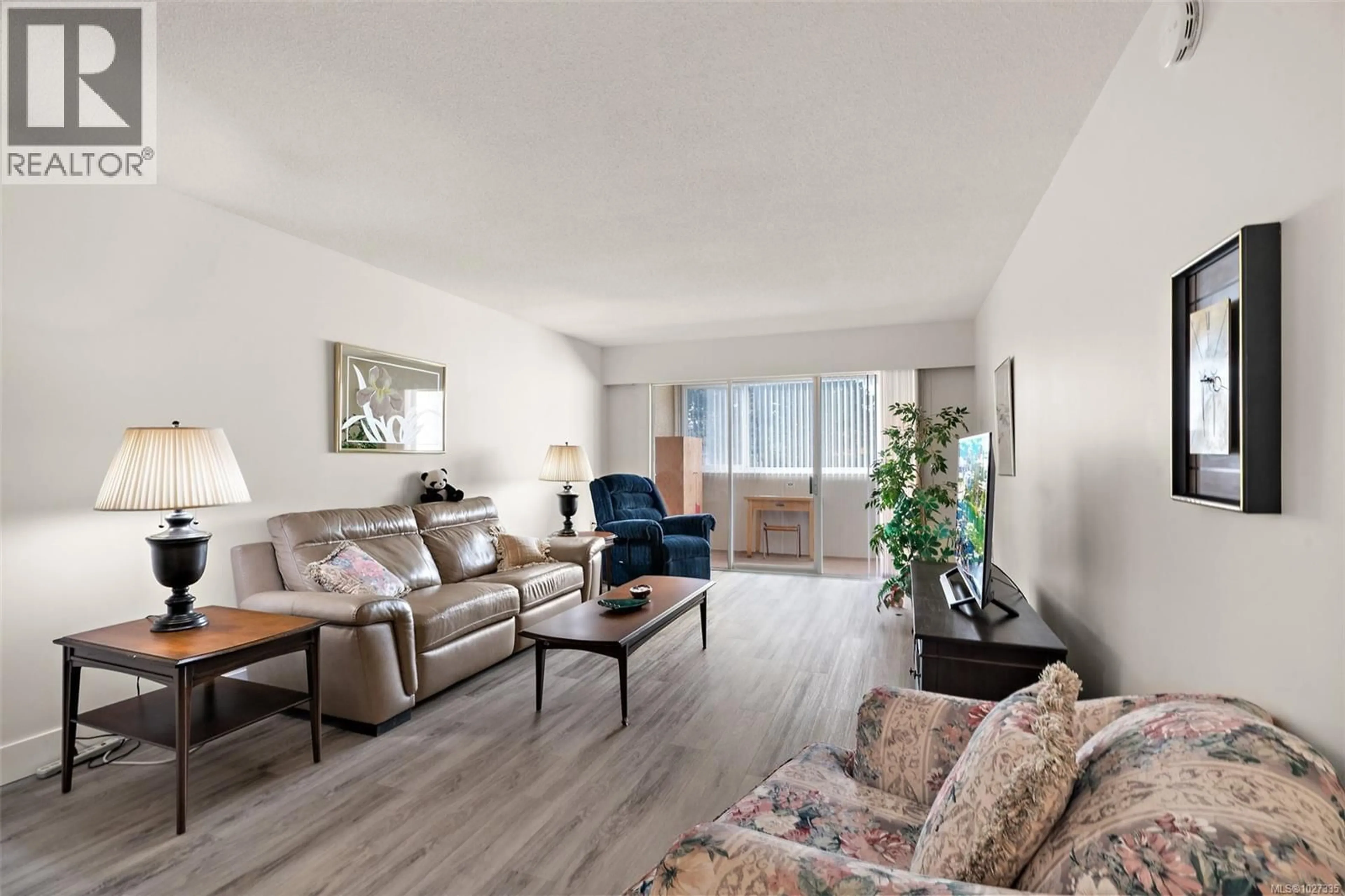 Living room with furniture, wood/laminate floor for 206 - 2050 WHITE BIRCH ROAD, Sidney British Columbia V8L2R2