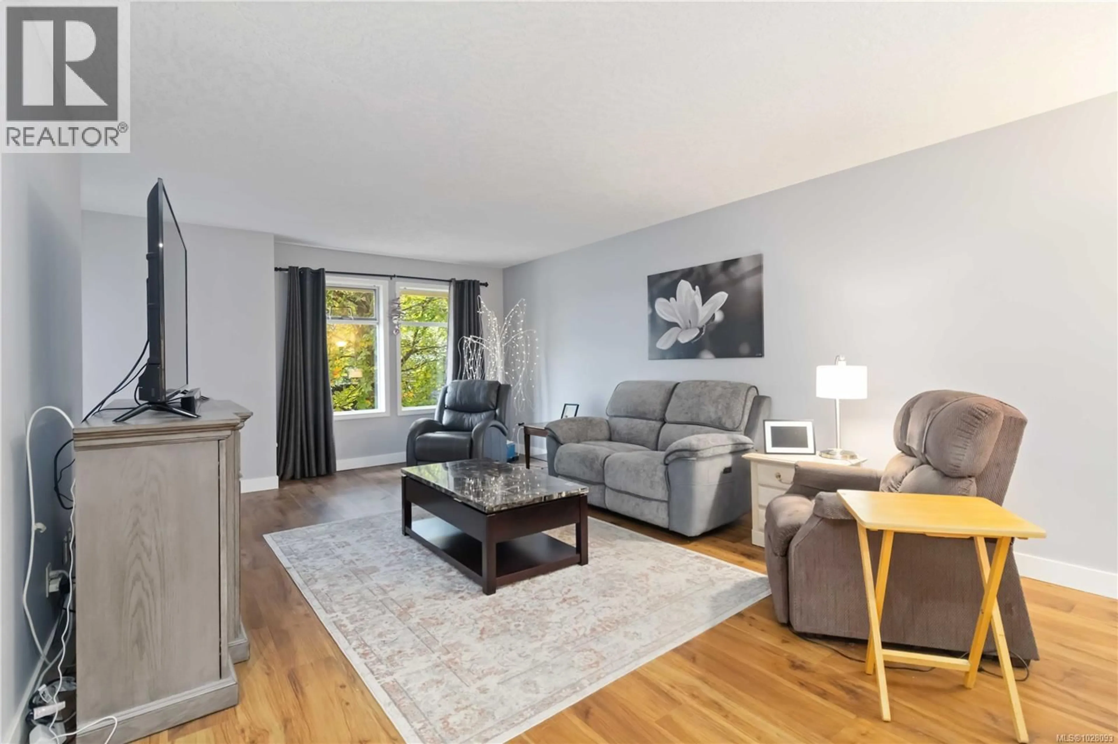 Living room with furniture, wood/laminate floor for 201 - 2311 MILLS ROAD, Sidney British Columbia V8L2C3
