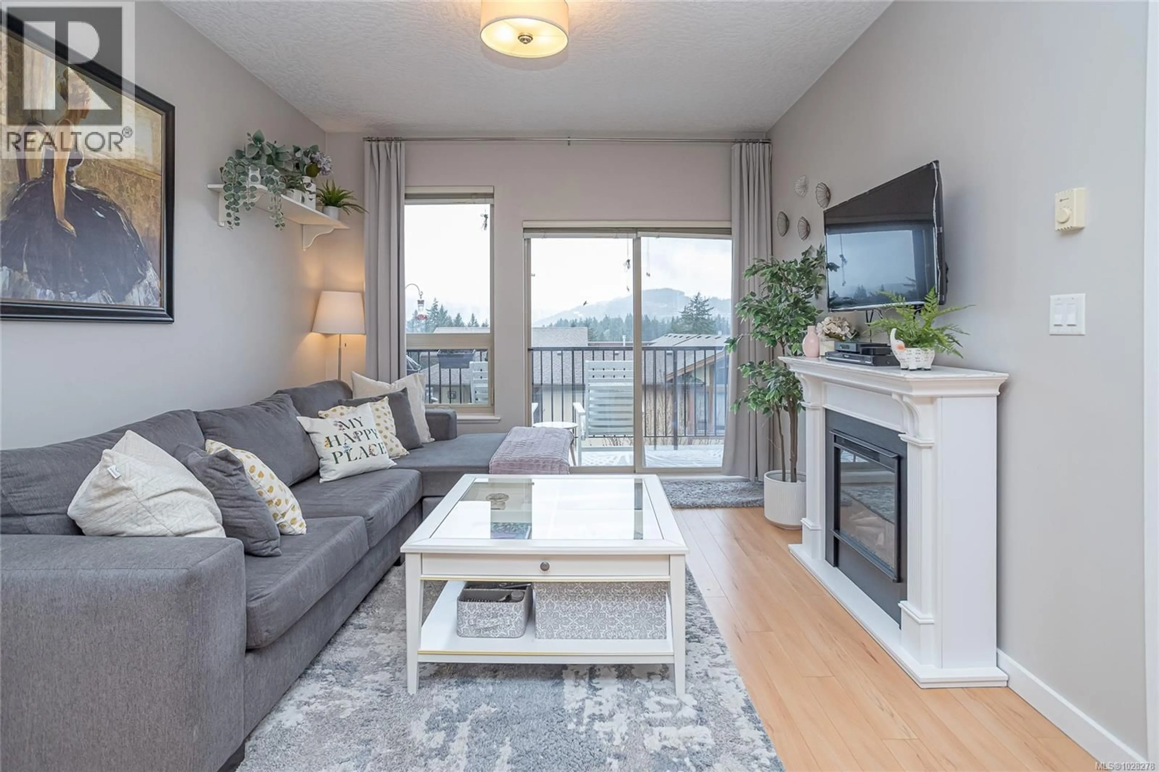 Living room with furniture, wood/laminate floor for 402 - 3240 JACKLIN ROAD, Langford British Columbia V9C3T6