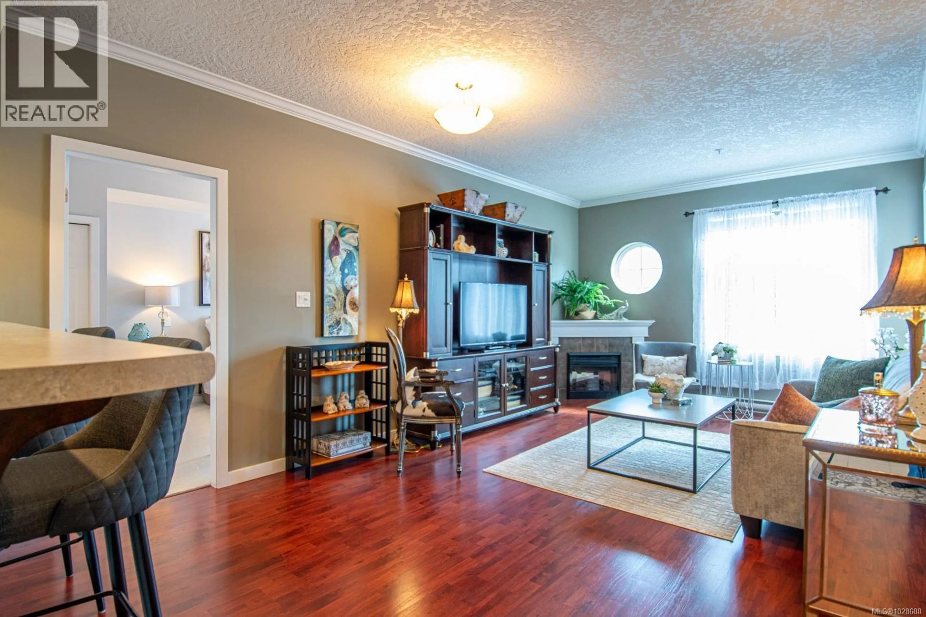 Living room with furniture, wood/laminate floor for 209 - 7088 WEST SAANICH ROAD, Central Saanich British Columbia V8M1P9