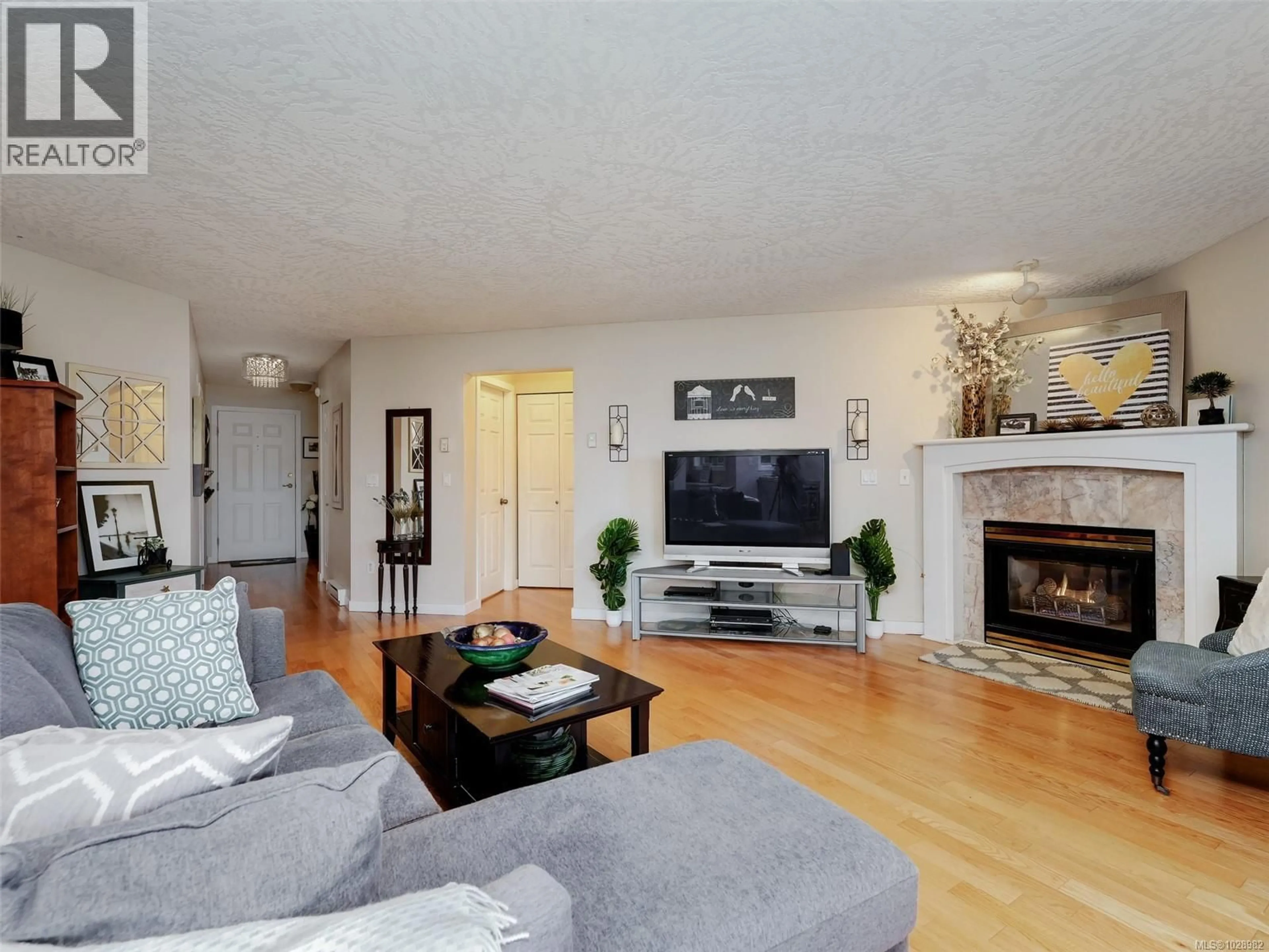 Living room with furniture, wood/laminate floor for 104 - 1687 POPLAR AVENUE, Saanich British Columbia V8P4K5
