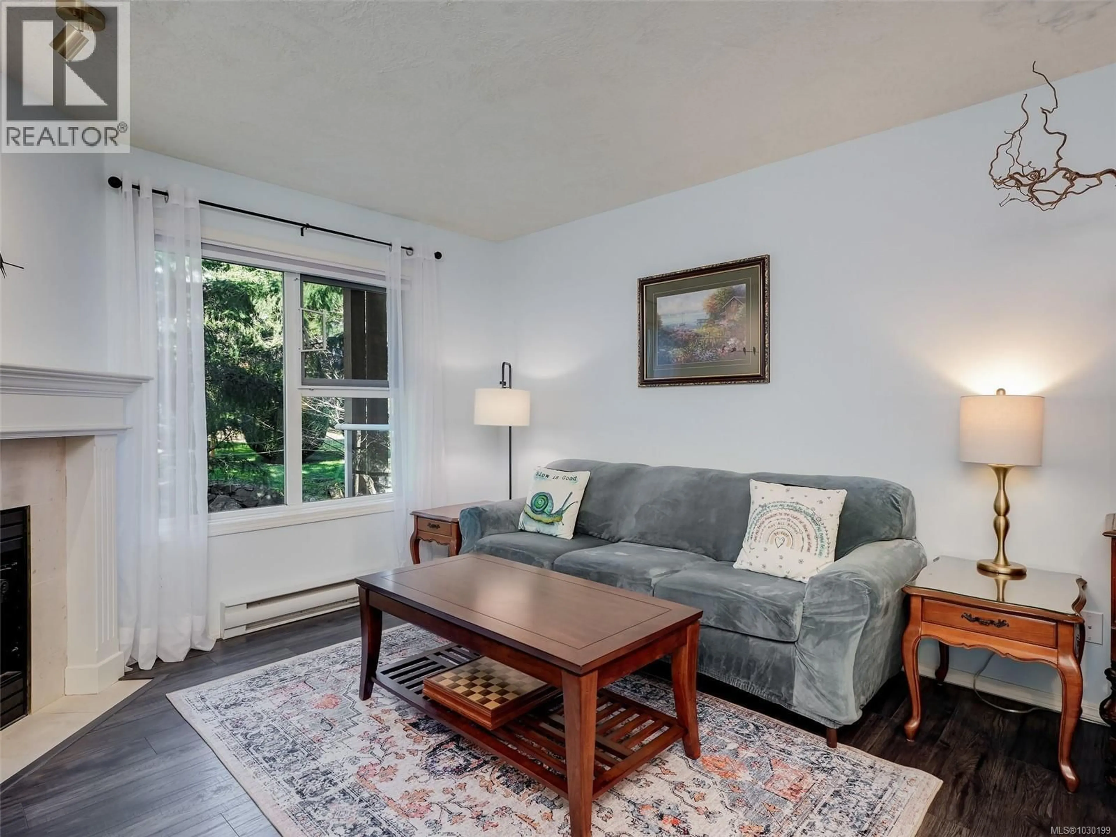 Living room with furniture, wood/laminate floor for 203 - 490 MARSETT PLACE, Saanich British Columbia V8Z7J1