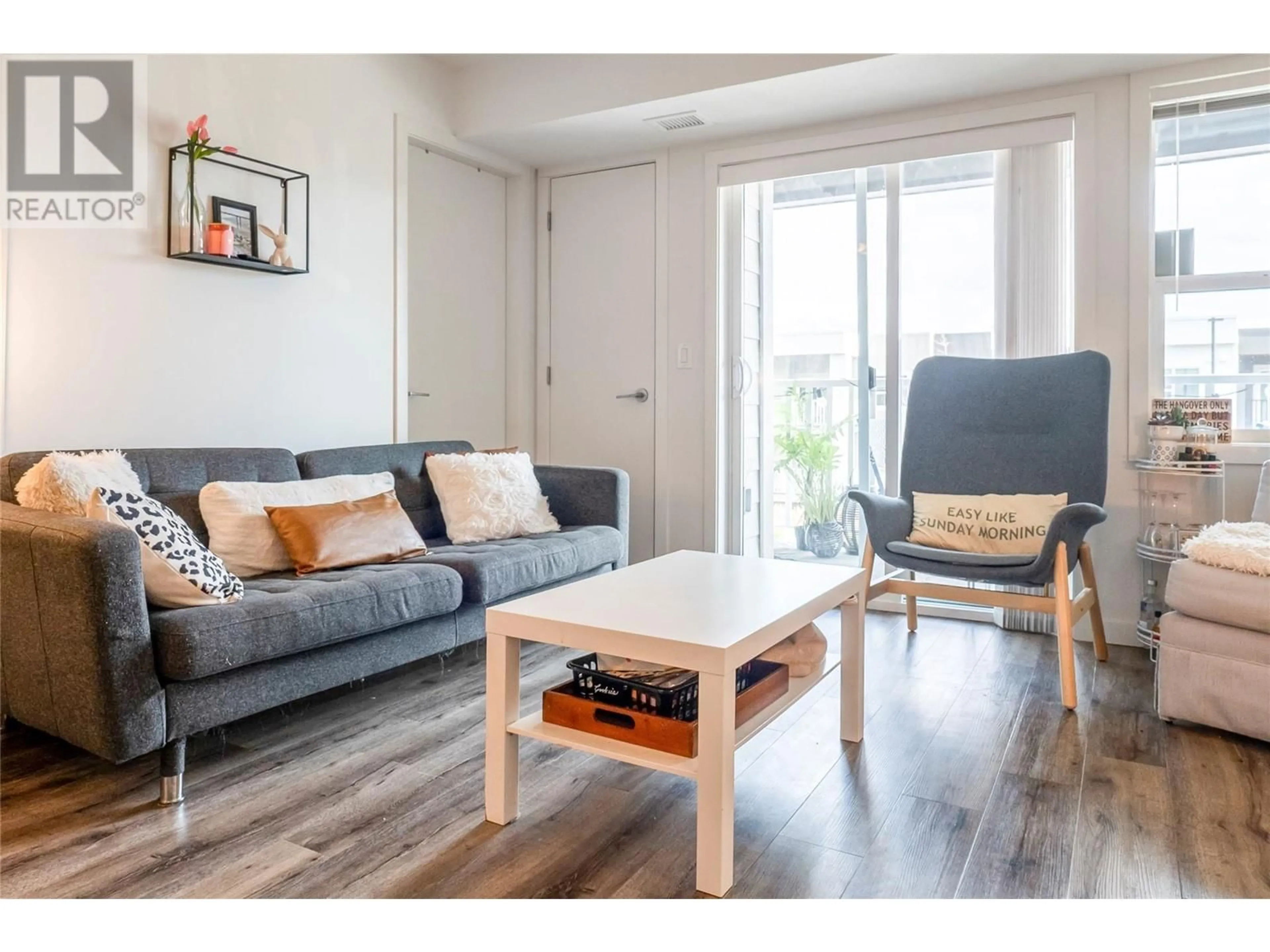 Living room with furniture, wood/laminate floor for 121 - 655 ACADEMY WAY, Kelowna British Columbia V1V0A2