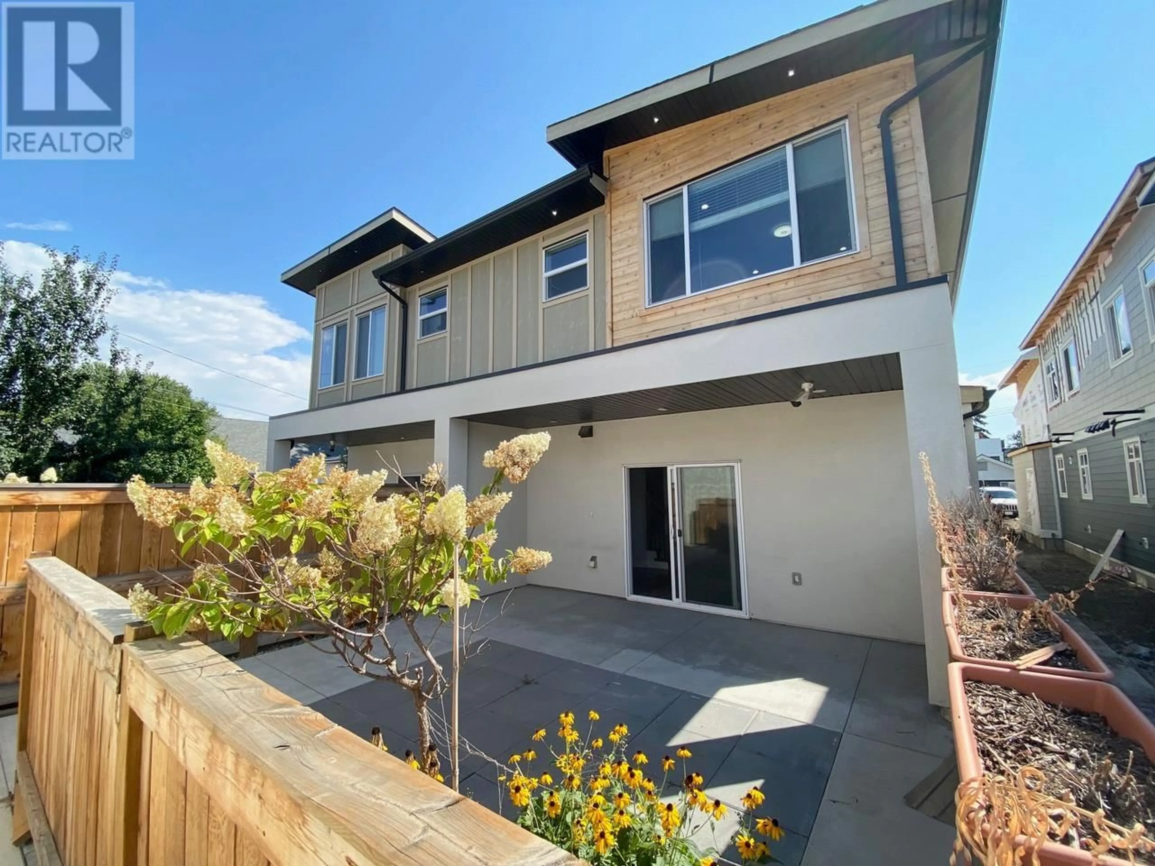 Frontside or backside of a home, the fenced backyard for 1056 Martin Avenue Unit# 3, Kelowna British Columbia V1Y6V5