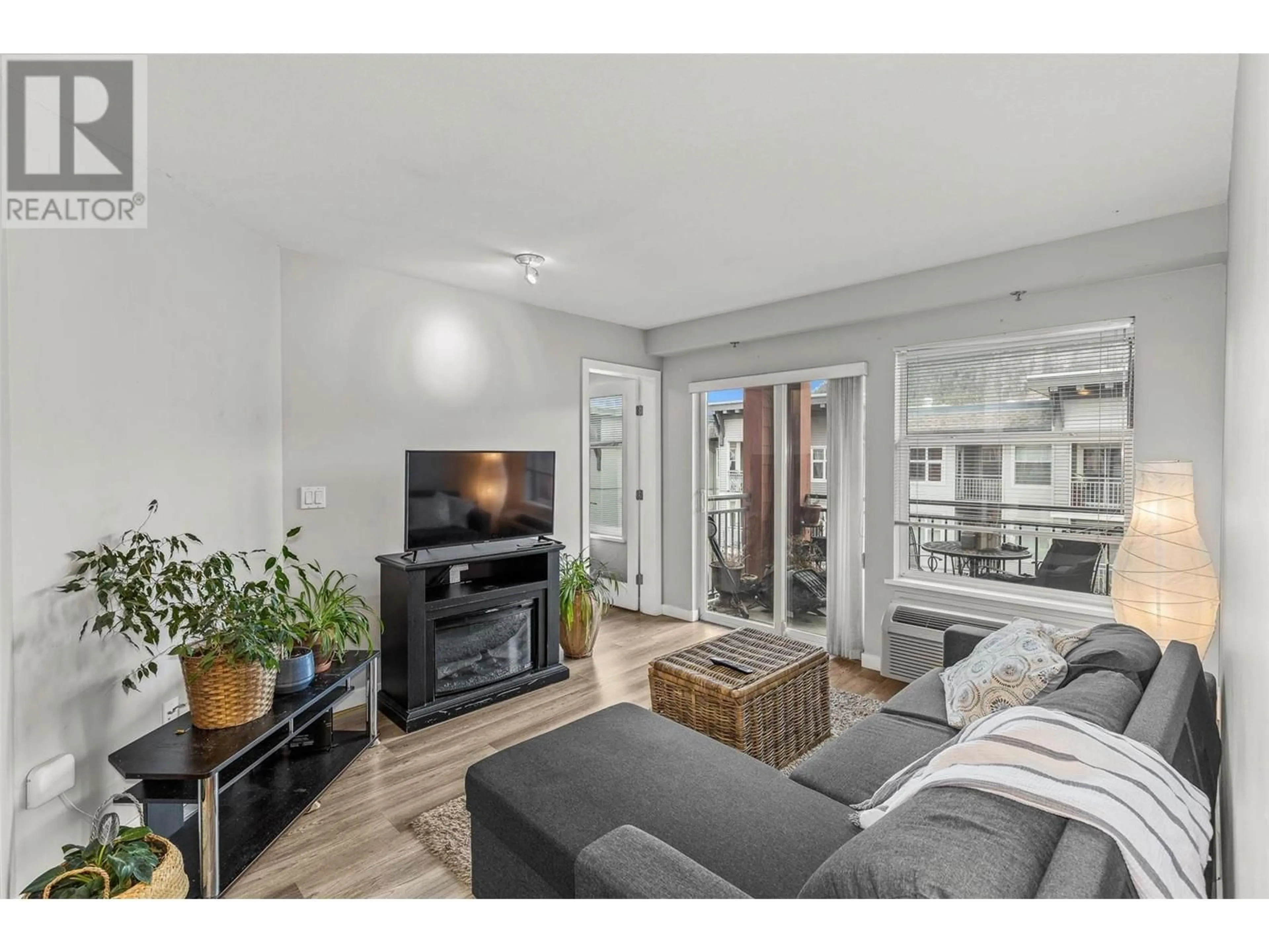 Living room with furniture, wood/laminate floor for 407 - 555 YATES ROAD, Kelowna British Columbia V1V2V2