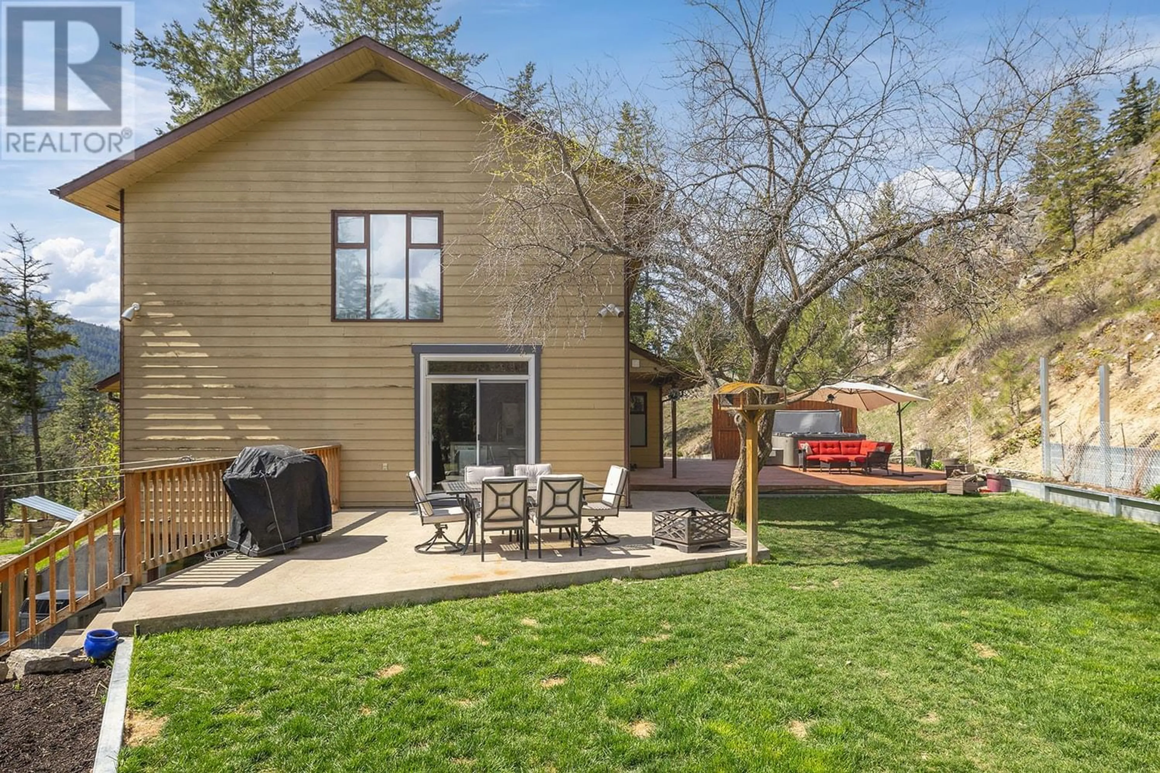 Frontside or backside of a home, the fenced backyard for 6750 Highway 33 E, Kelowna British Columbia V1P1H9