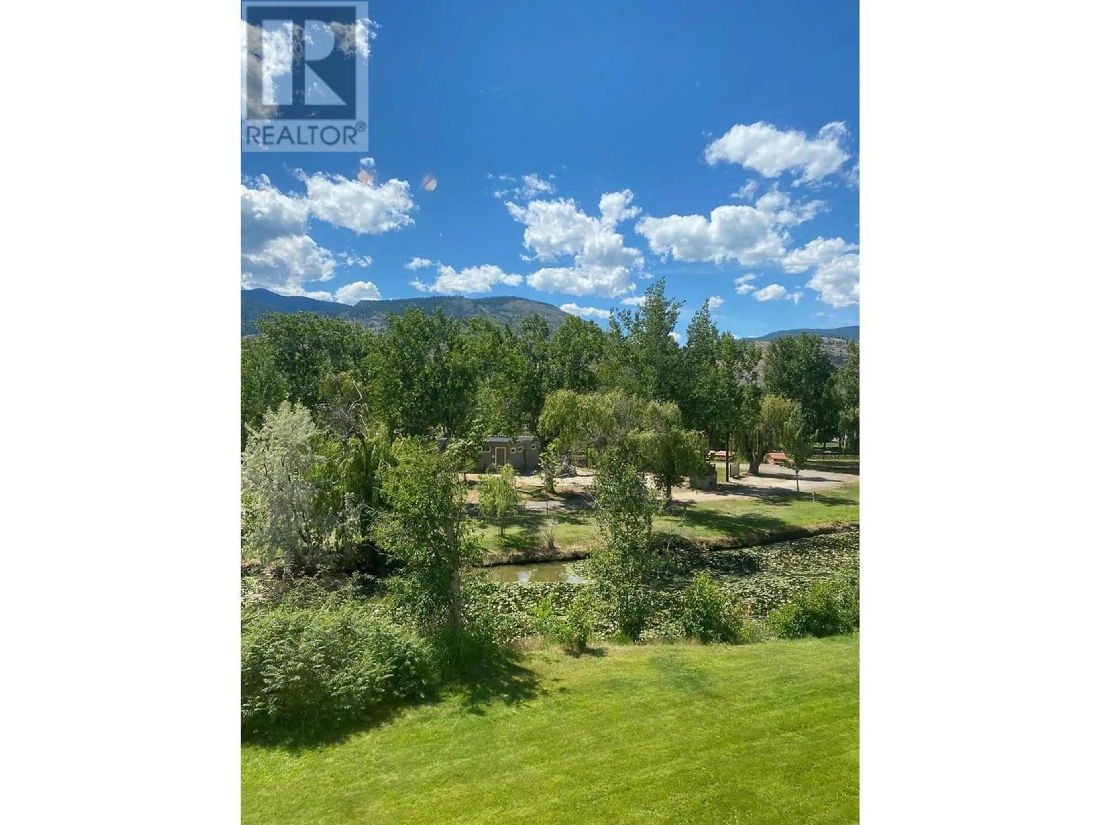 A pic from exterior of the house or condo, the fenced backyard for 150 Skaha Place Unit# 205, Penticton British Columbia V2A7L1