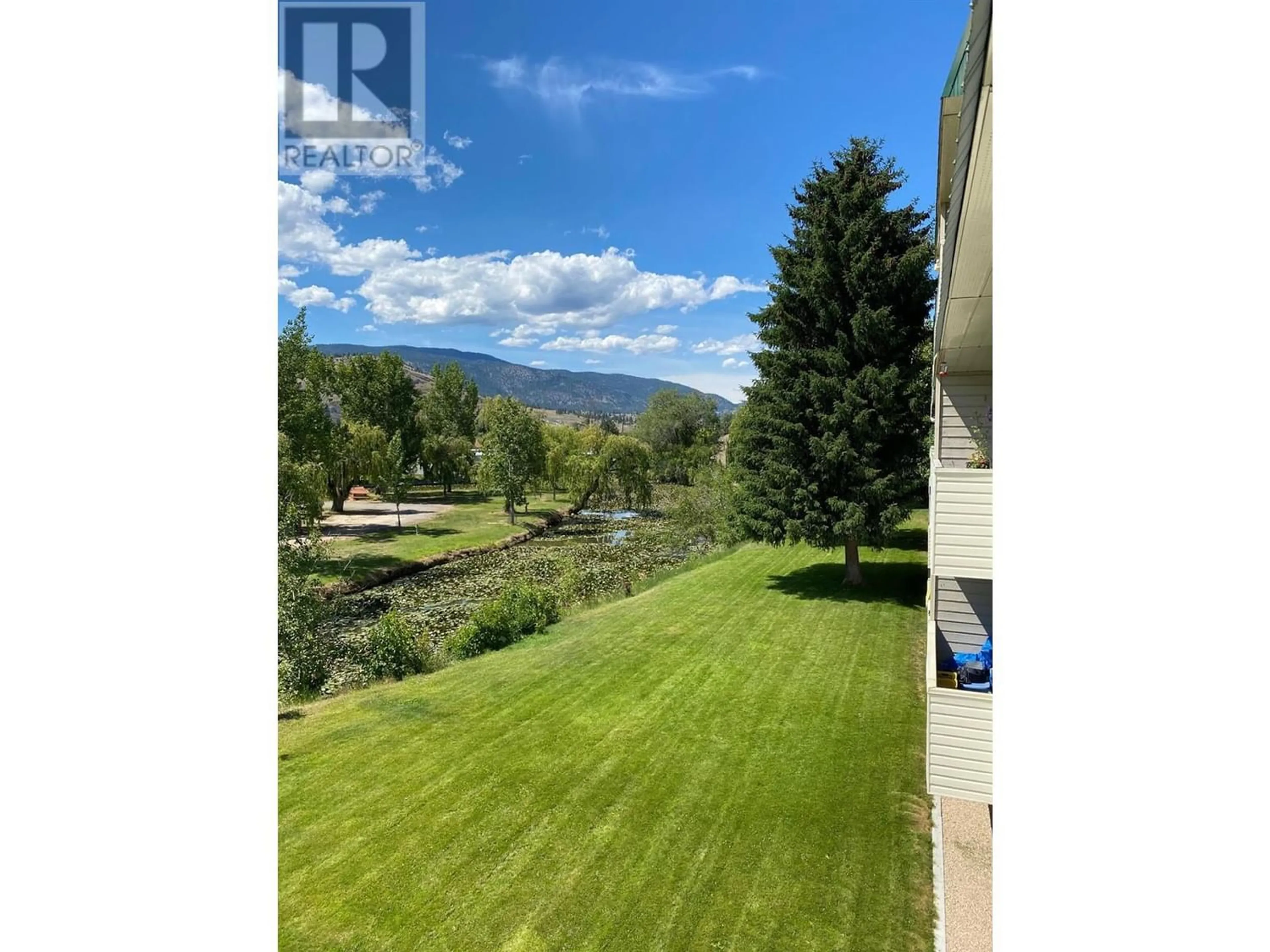 A pic from exterior of the house or condo, the fenced backyard for 150 Skaha Place Unit# 205, Penticton British Columbia V2A7L1