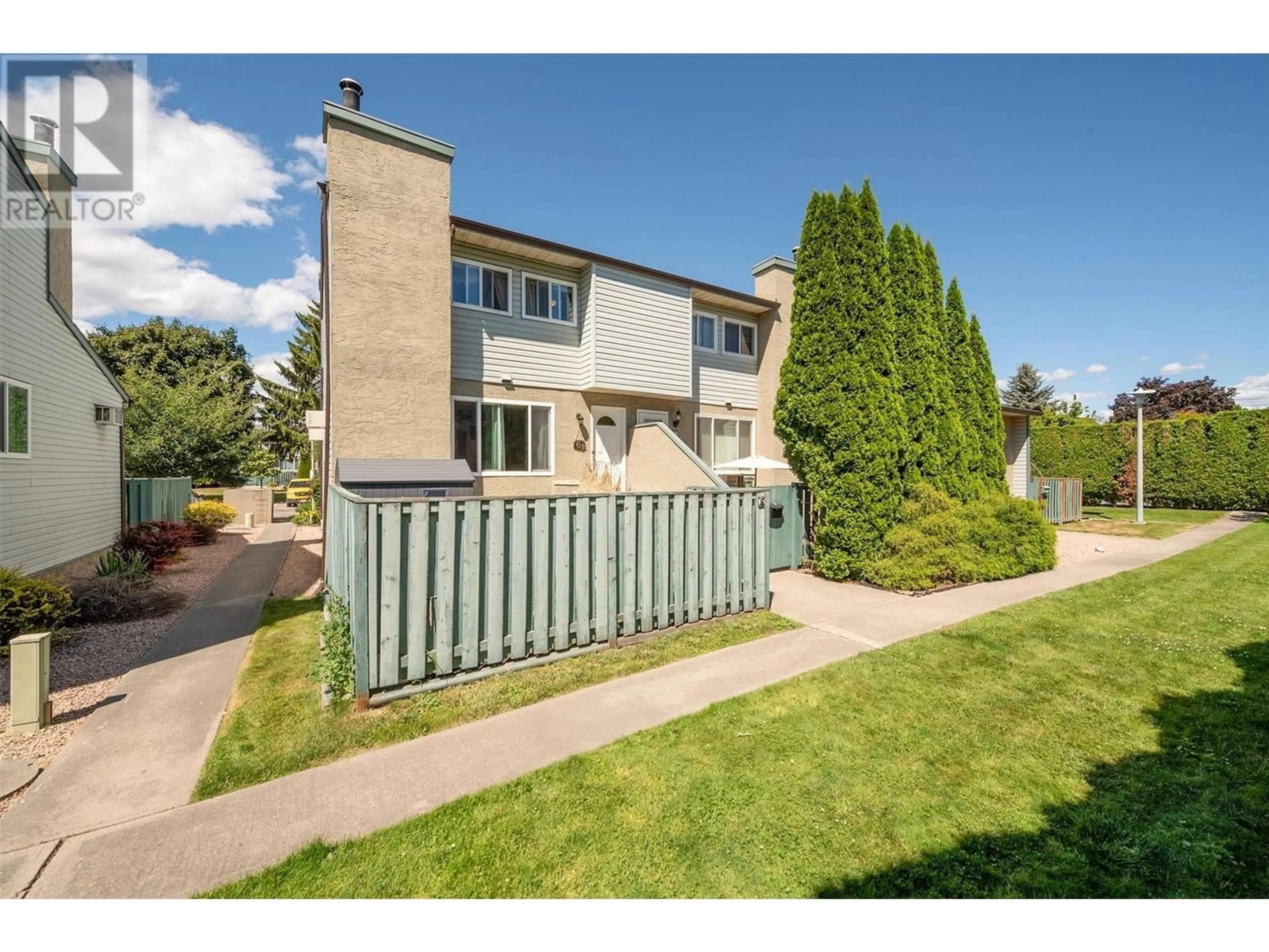 A pic from exterior of the house or condo, the fenced backyard for 1471 Inkar Road Unit# 6, Kelowna British Columbia V1Y8J1