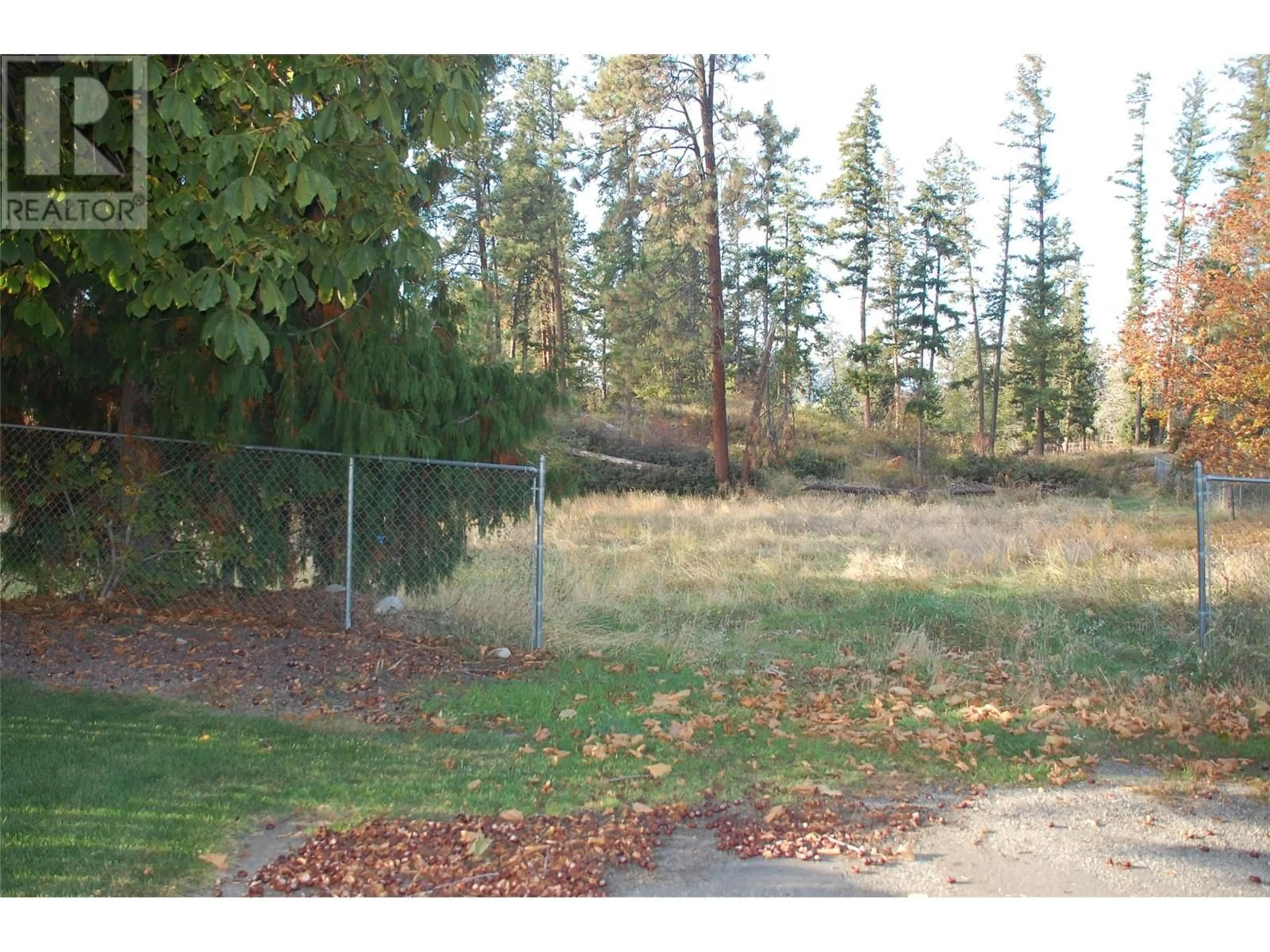 A pic from exterior of the house or condo, the fenced backyard for 3297 Hall Road, Kelowna British Columbia V1W2V1