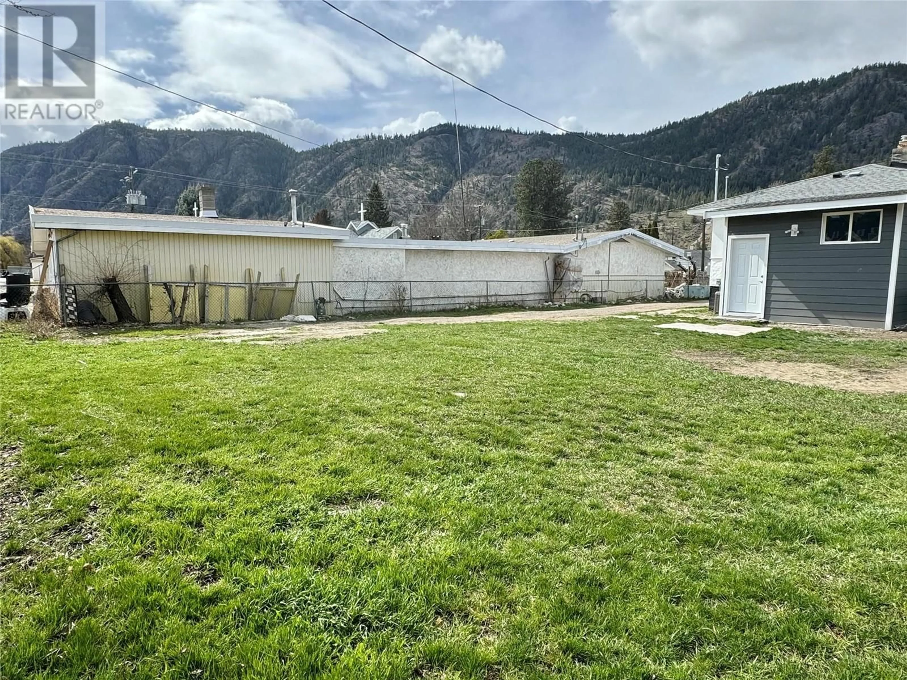 Frontside or backside of a home, the fenced backyard for 1021 Willow Street, Okanagan Falls British Columbia V0H1R4