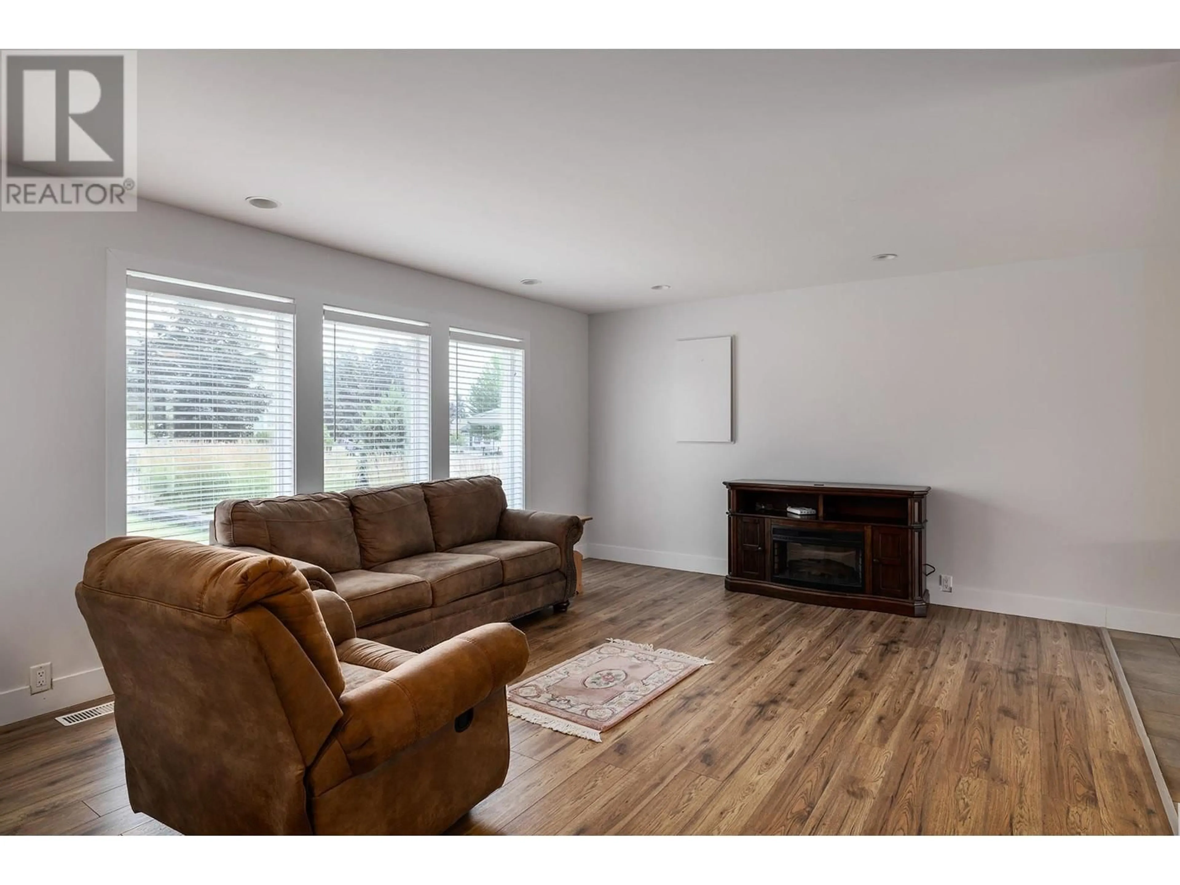 Living room with furniture, wood/laminate floor for 2571 Pineridge Place, West Kelowna British Columbia V4T2J7