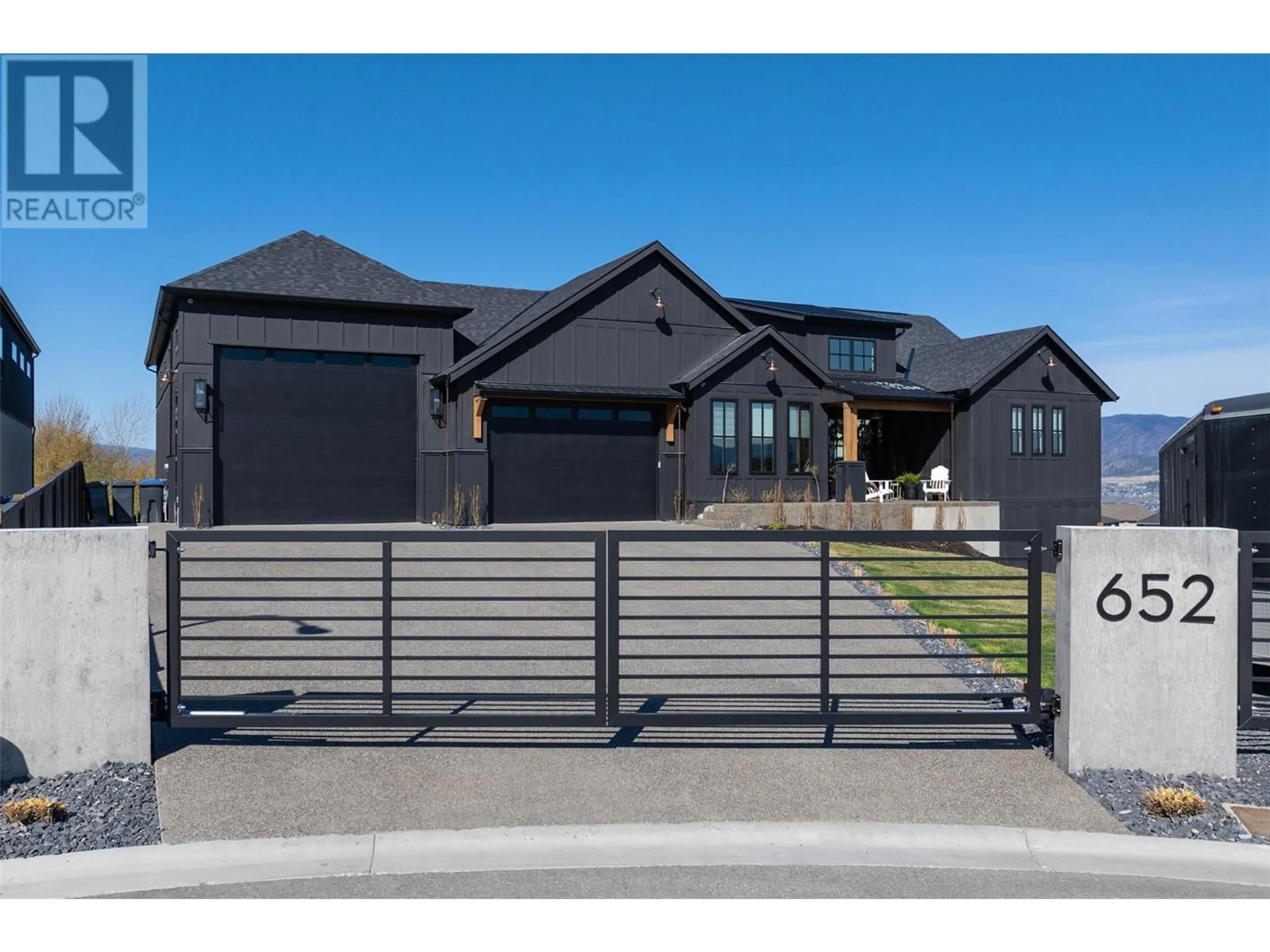 Frontside or backside of a home, the fenced backyard for 652 Trumpeter Road, Kelowna British Columbia V1W4L6