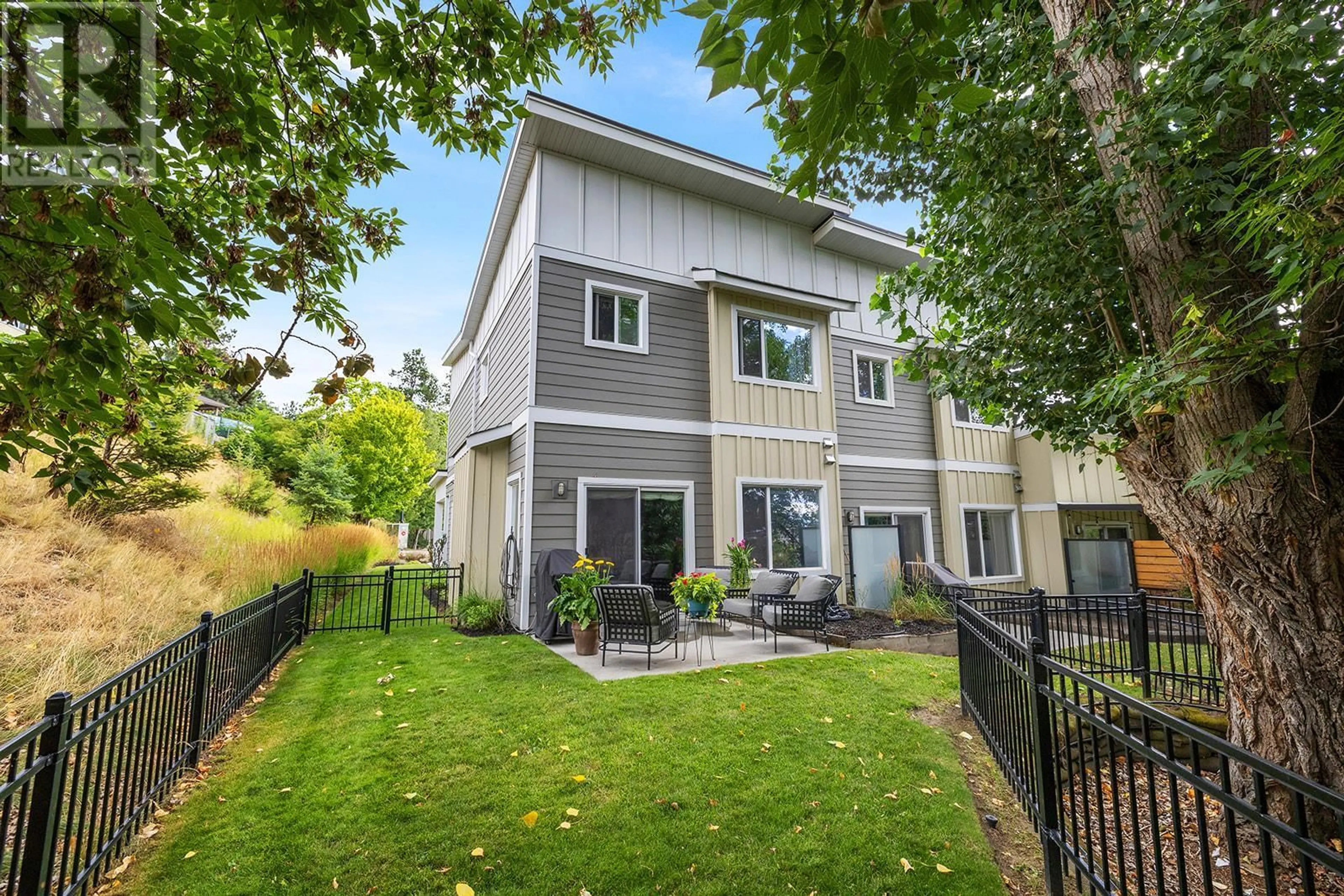 A pic from exterior of the house or condo, the fenced backyard for 1170 Brant Avenue Unit# 8, Kelowna British Columbia V1Y1N1