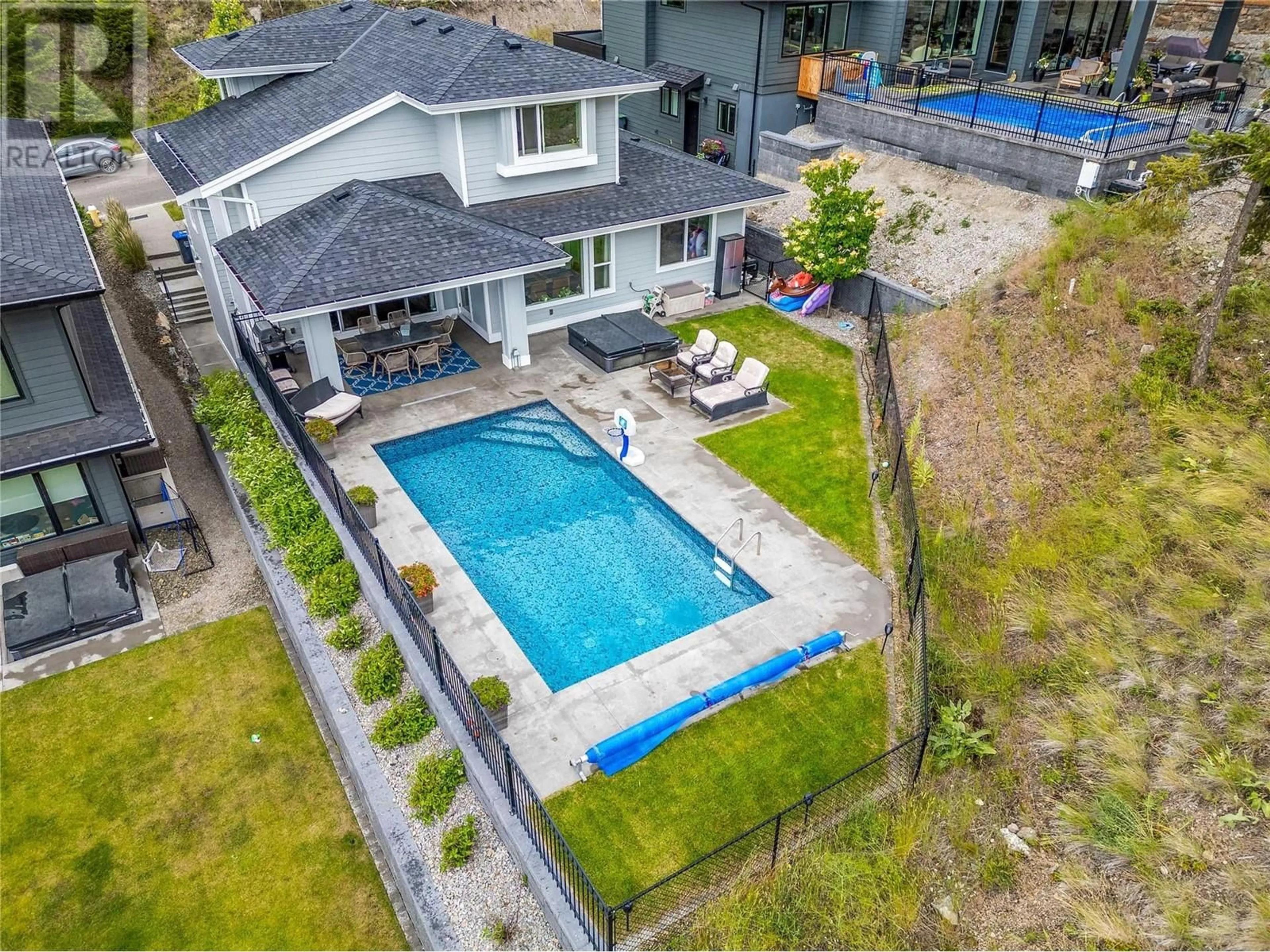 Frontside or backside of a home, the fenced backyard for 115 Echo Ridge Drive, Kelowna British Columbia V1V0C9