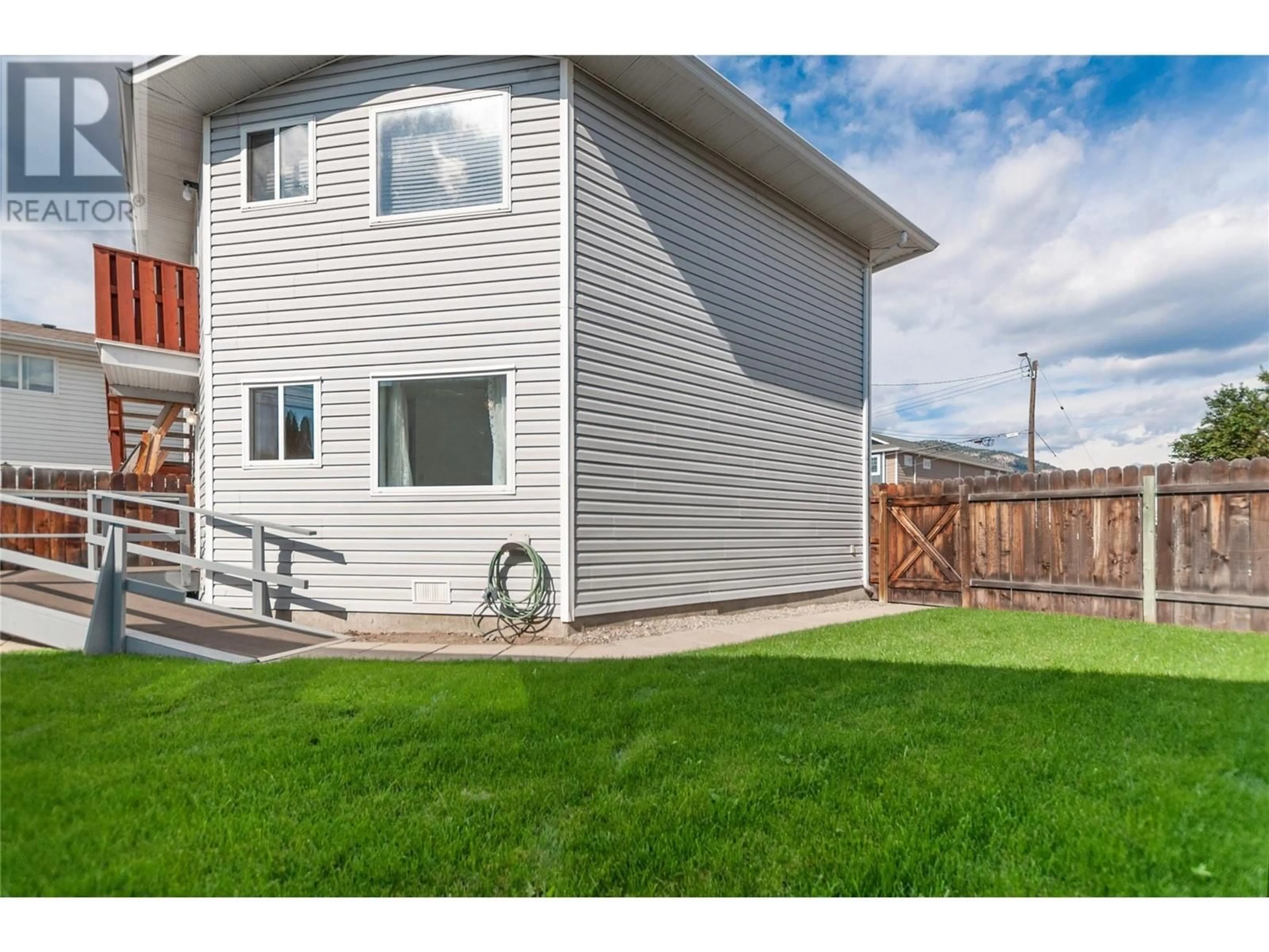 Frontside or backside of a home, the fenced backyard for 402 Rene Avenue Unit# 101, Penticton British Columbia V2A7M2