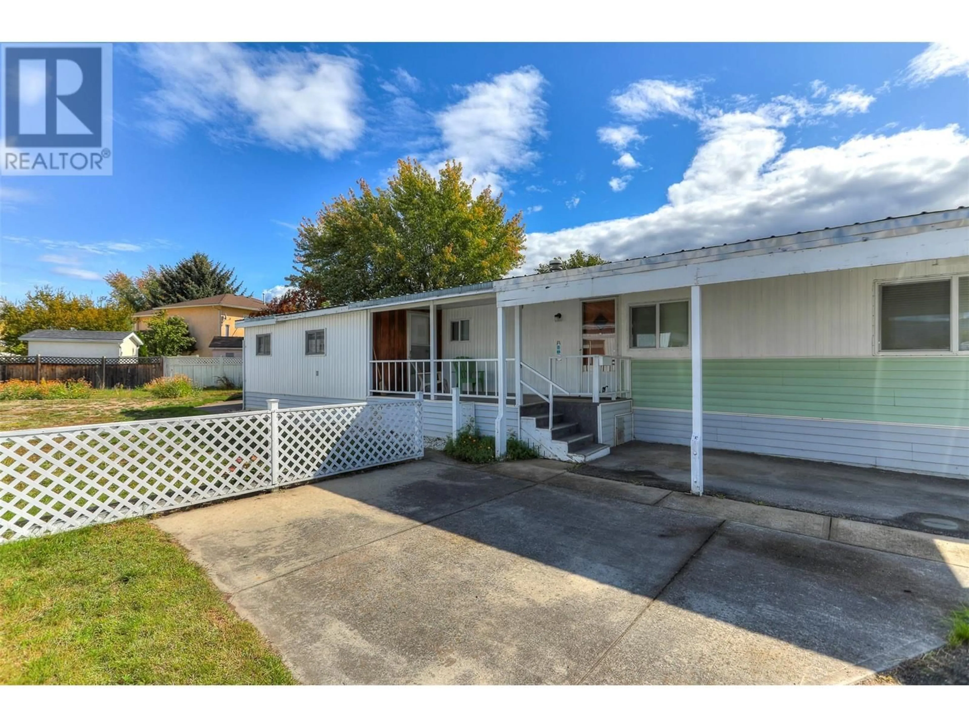 Frontside or backside of a home, the fenced backyard for 3745 Lakeshore Road Unit# 116, Kelowna British Columbia V1W3K4