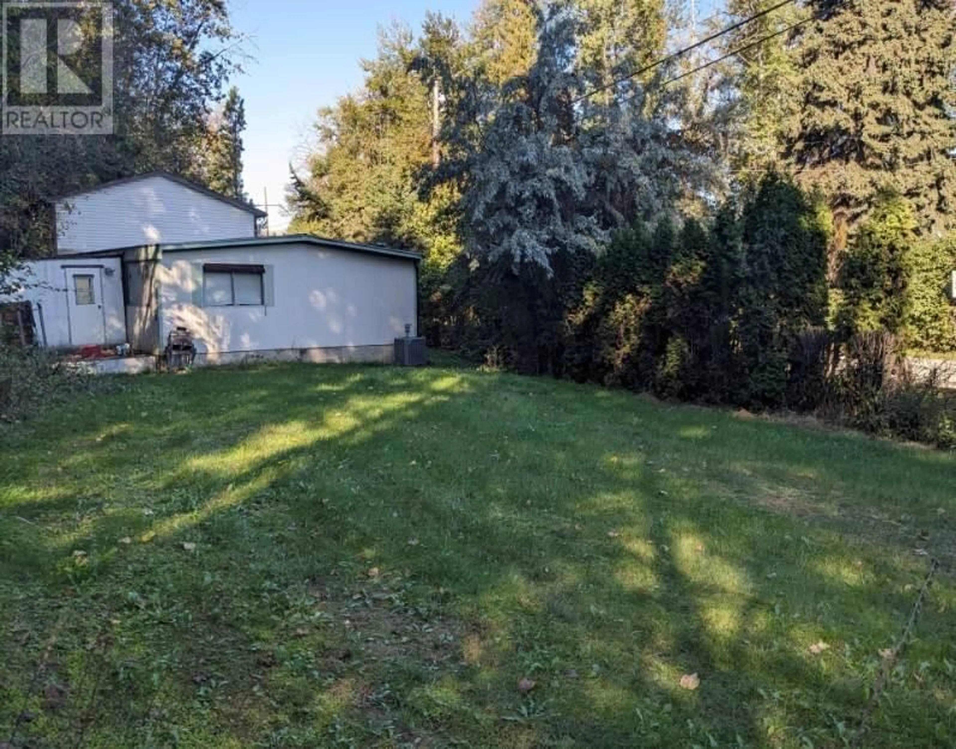 Frontside or backside of a home, the fenced backyard for 1300 46 Avenue, Vernon British Columbia V1T3P2