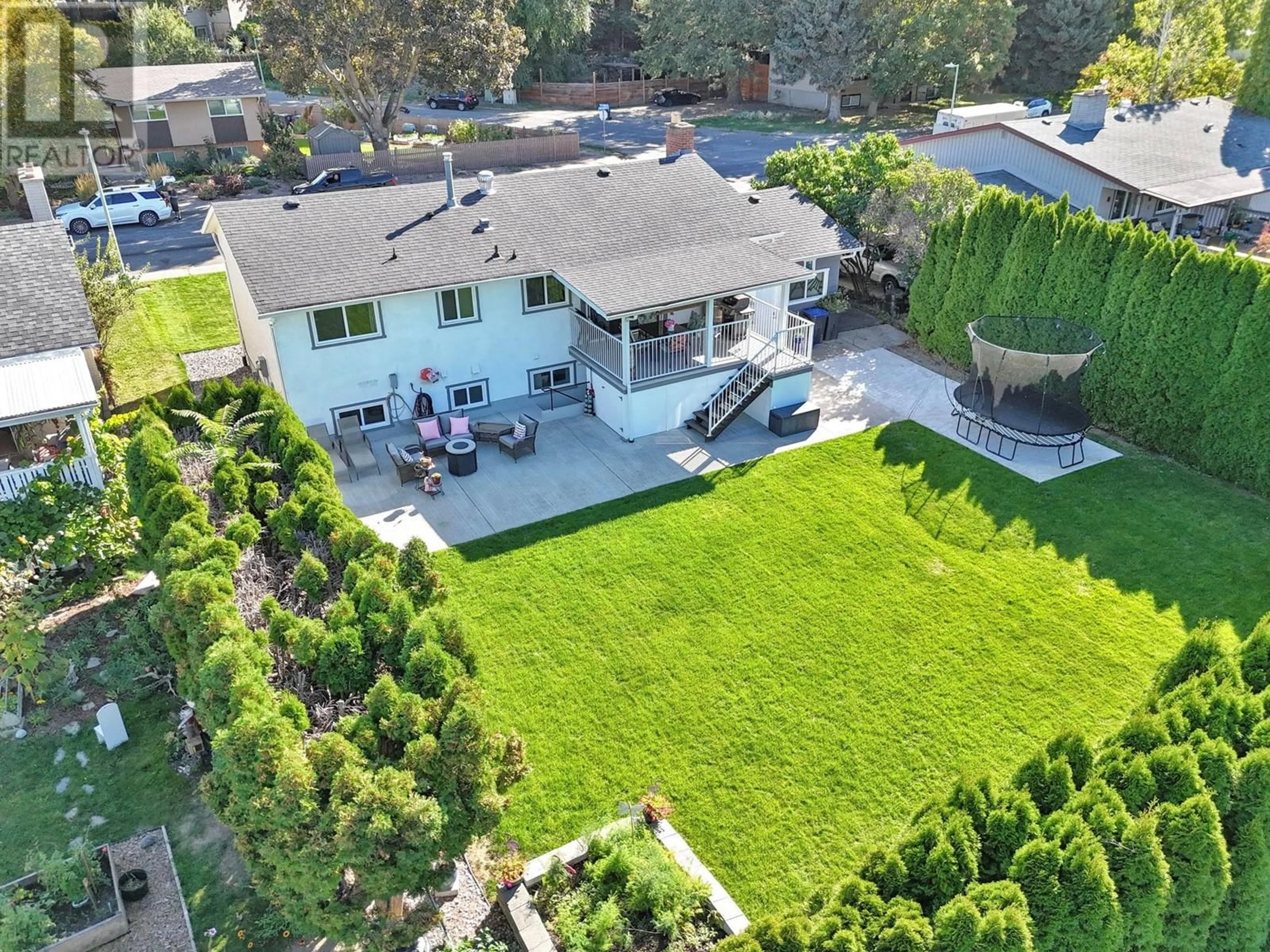 Frontside or backside of a home, the fenced backyard for 1408 Richmond Street, Kelowna British Columbia V1Y3T1