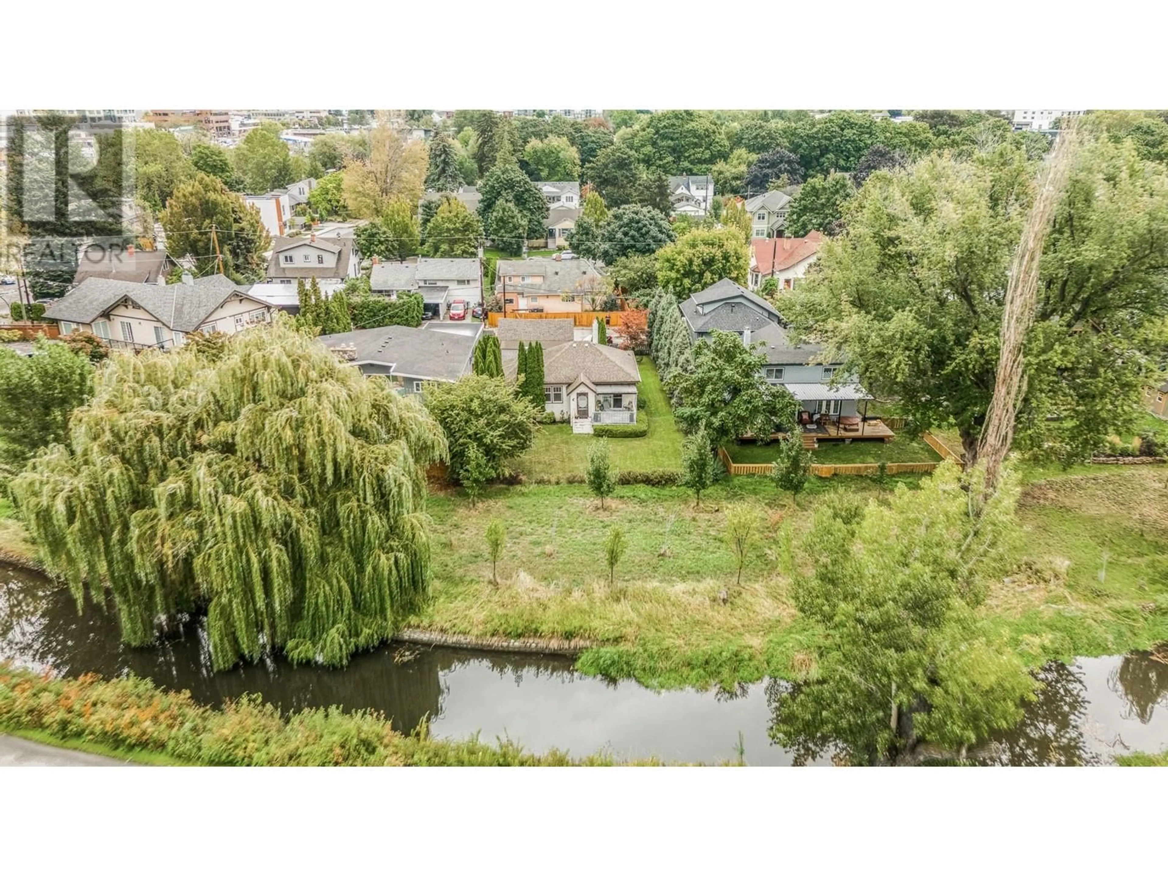 A pic from exterior of the house or condo, the fenced backyard for 1830 Riverside Avenue, Kelowna British Columbia V1Y1A7