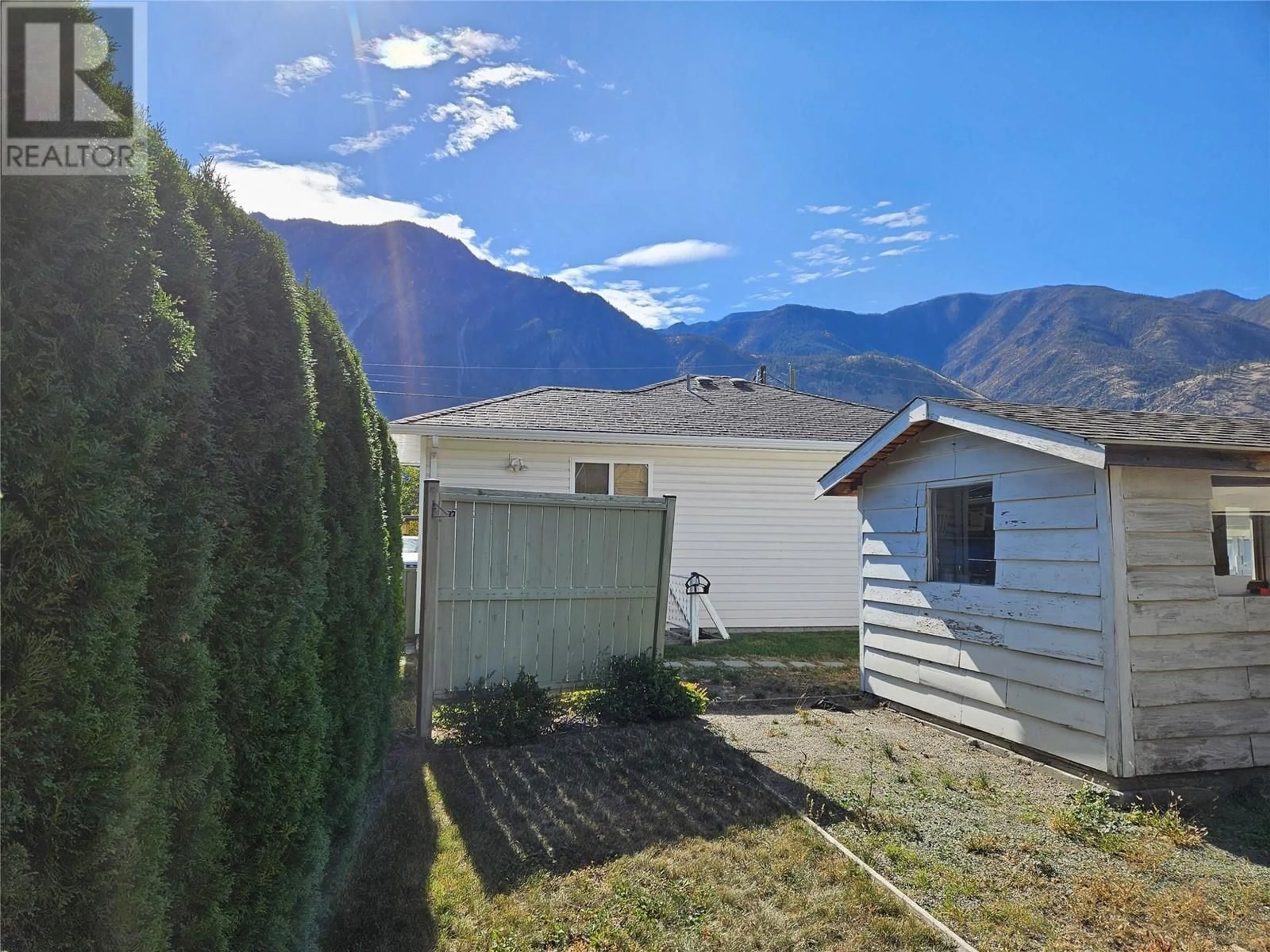 Frontside or backside of a home, the fenced backyard for 724 6th Avenue, Keremeos British Columbia V0X1N3