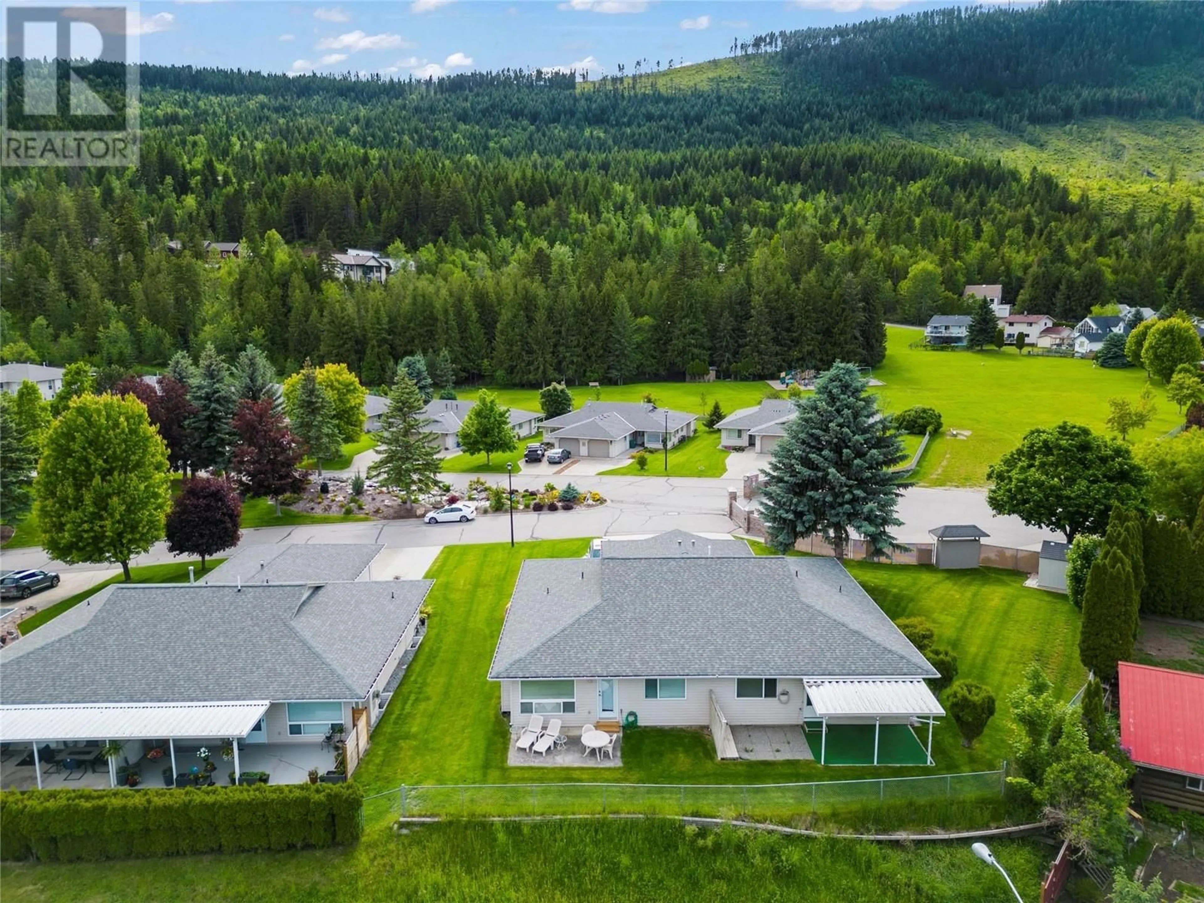 Frontside or backside of a home, the fenced backyard for 2675 Pine Avenue Unit# 2, Lumby British Columbia V0E2G0